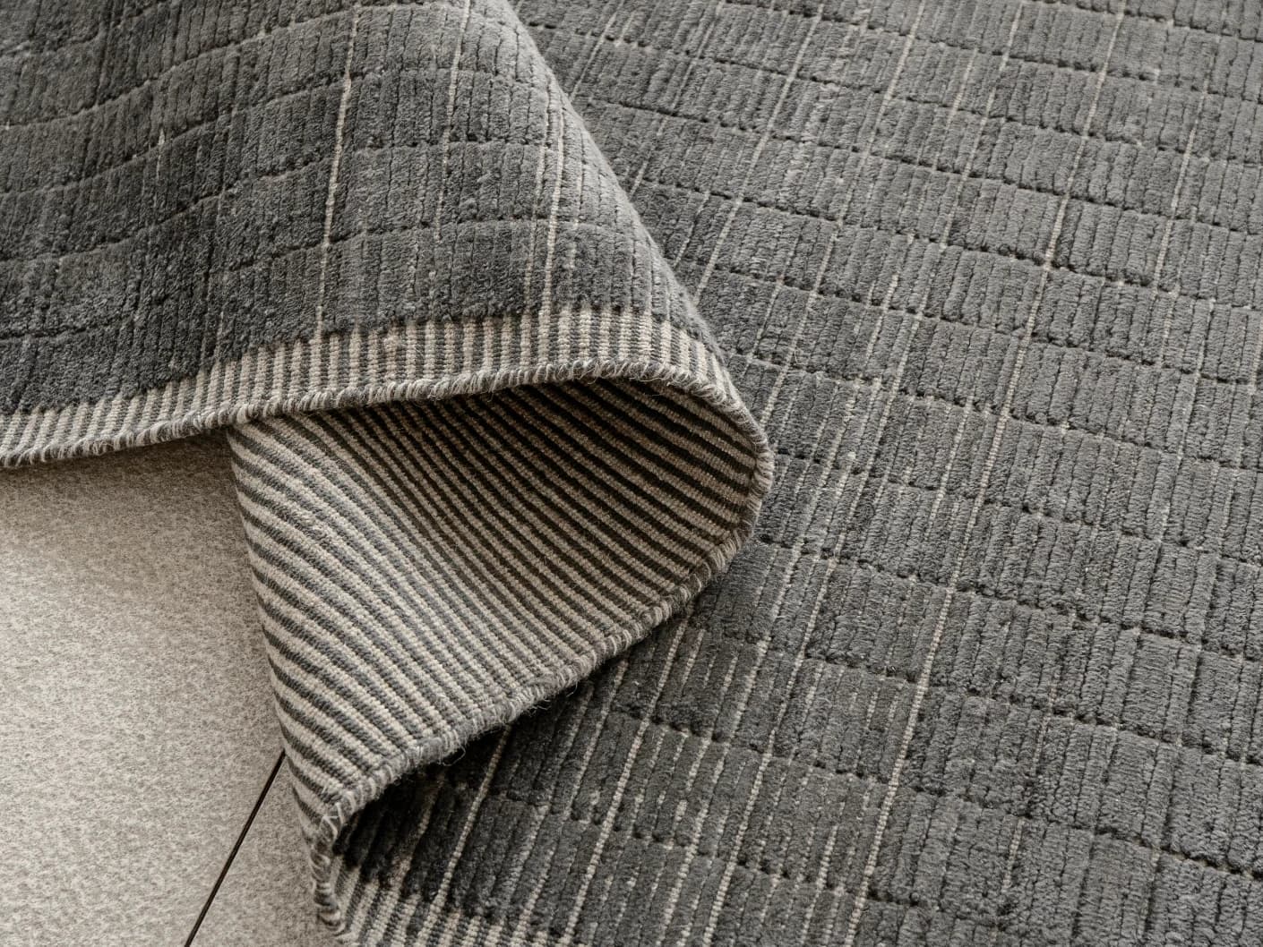 Taylor Ebony Round carpets in ebony, black and grey, shown in a product close-up view