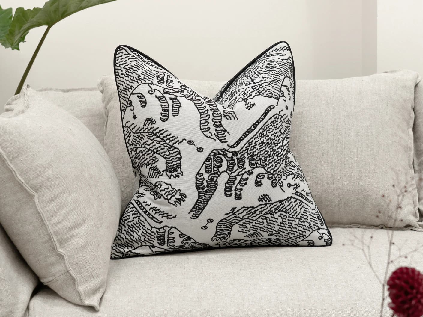 Tessa Steele single cushions in ivory and charcoal, shown in a lifestyle front view