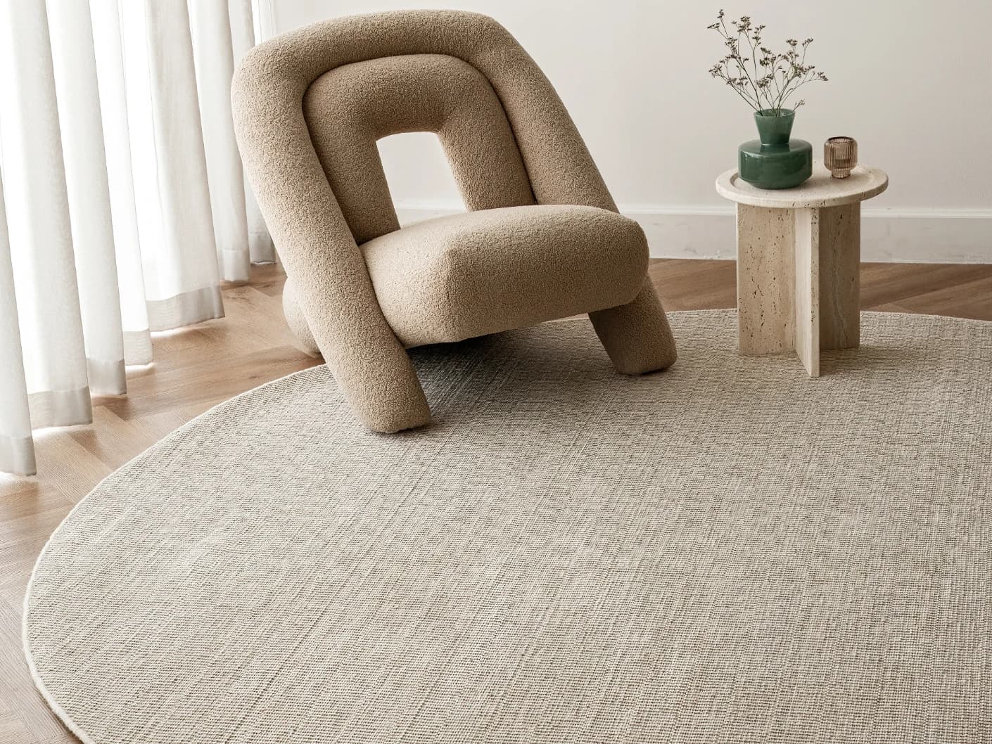 Treva Stone Round carpet in beige and taupe, shown in a lifestyle front view