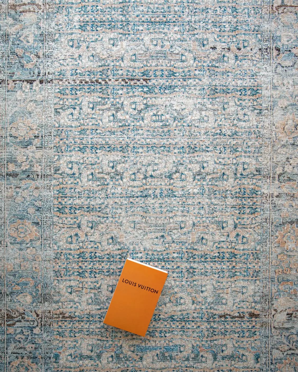 Vince Lake carpet in blue and rust, shown in a lifestyle top view as image 7