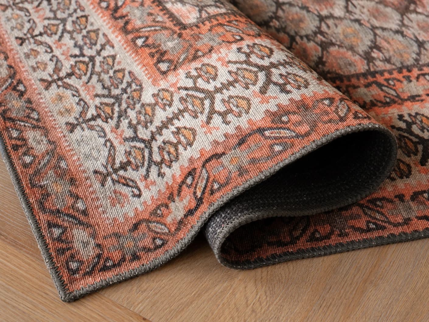 Vincent Copper carpets in taupe, orange and multicolour, shown in a product close-up view