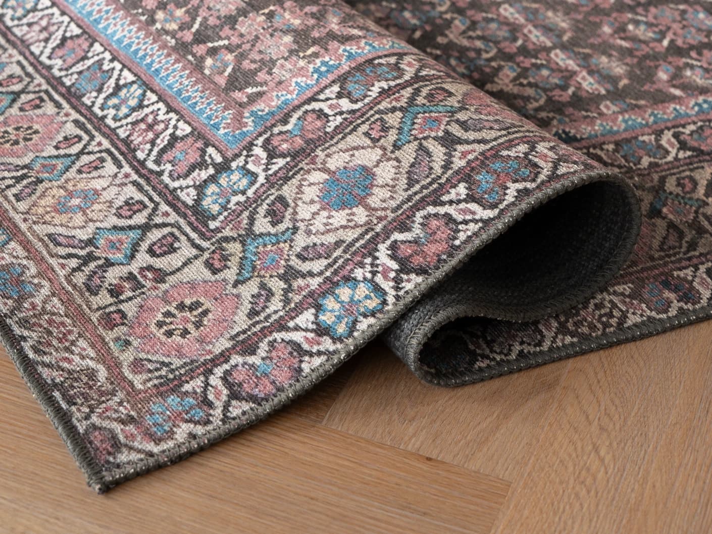Vincent Umber carpets in red, blue and multicolour, shown in a product close-up view