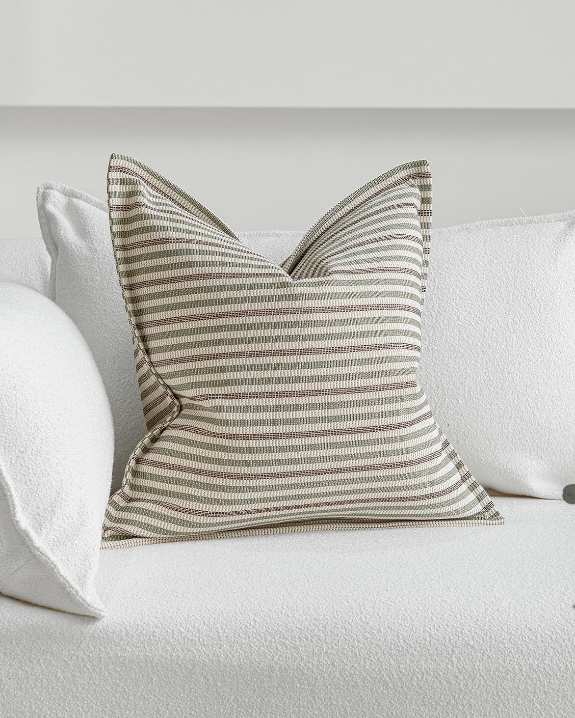 Wren Pistachio cushion in green and ivory, shown in a lifestyle front view as image 2
