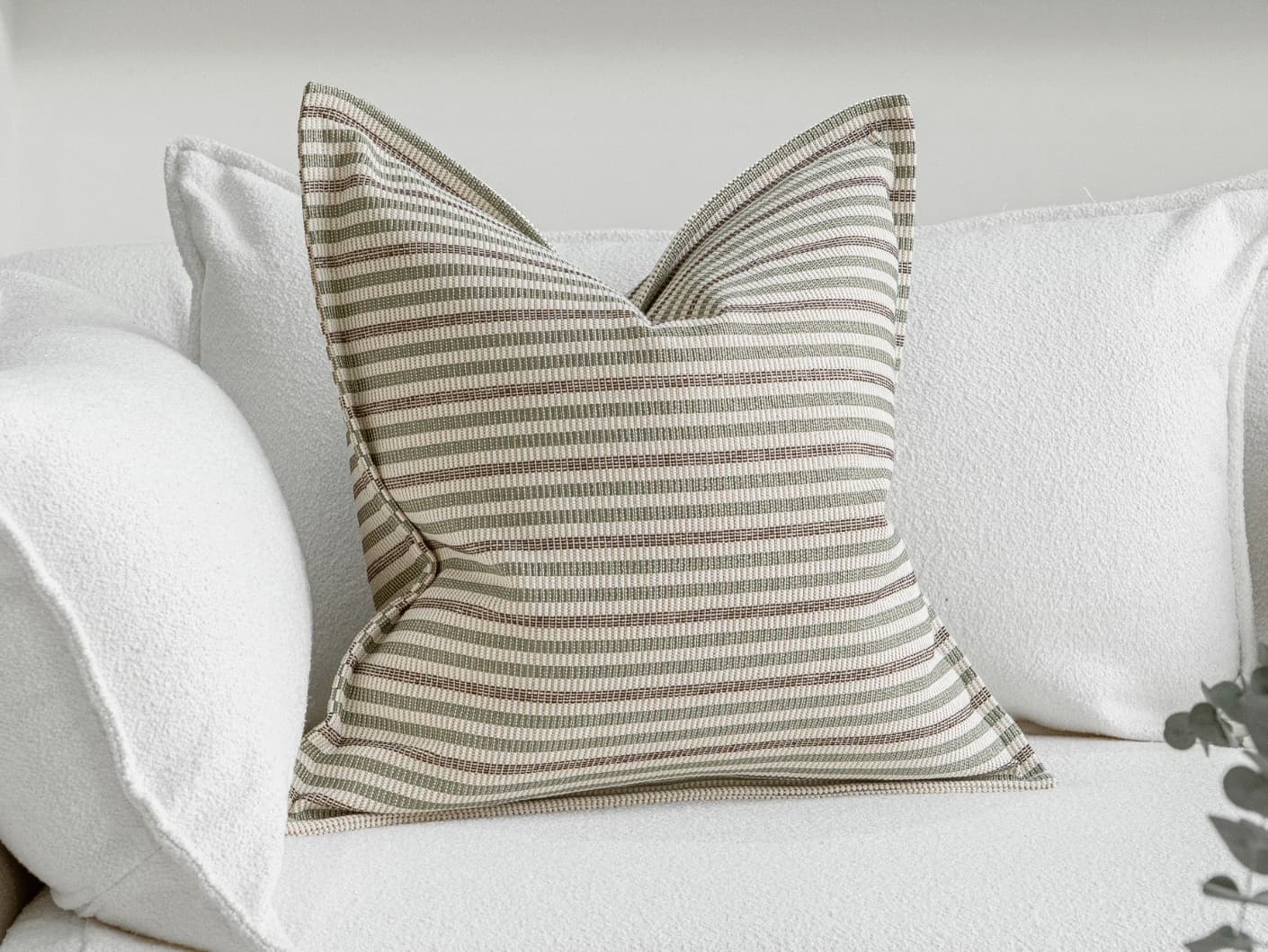 Wren Pistachio single cushions in pistachio, green and ivory, shown in a lifestyle front view