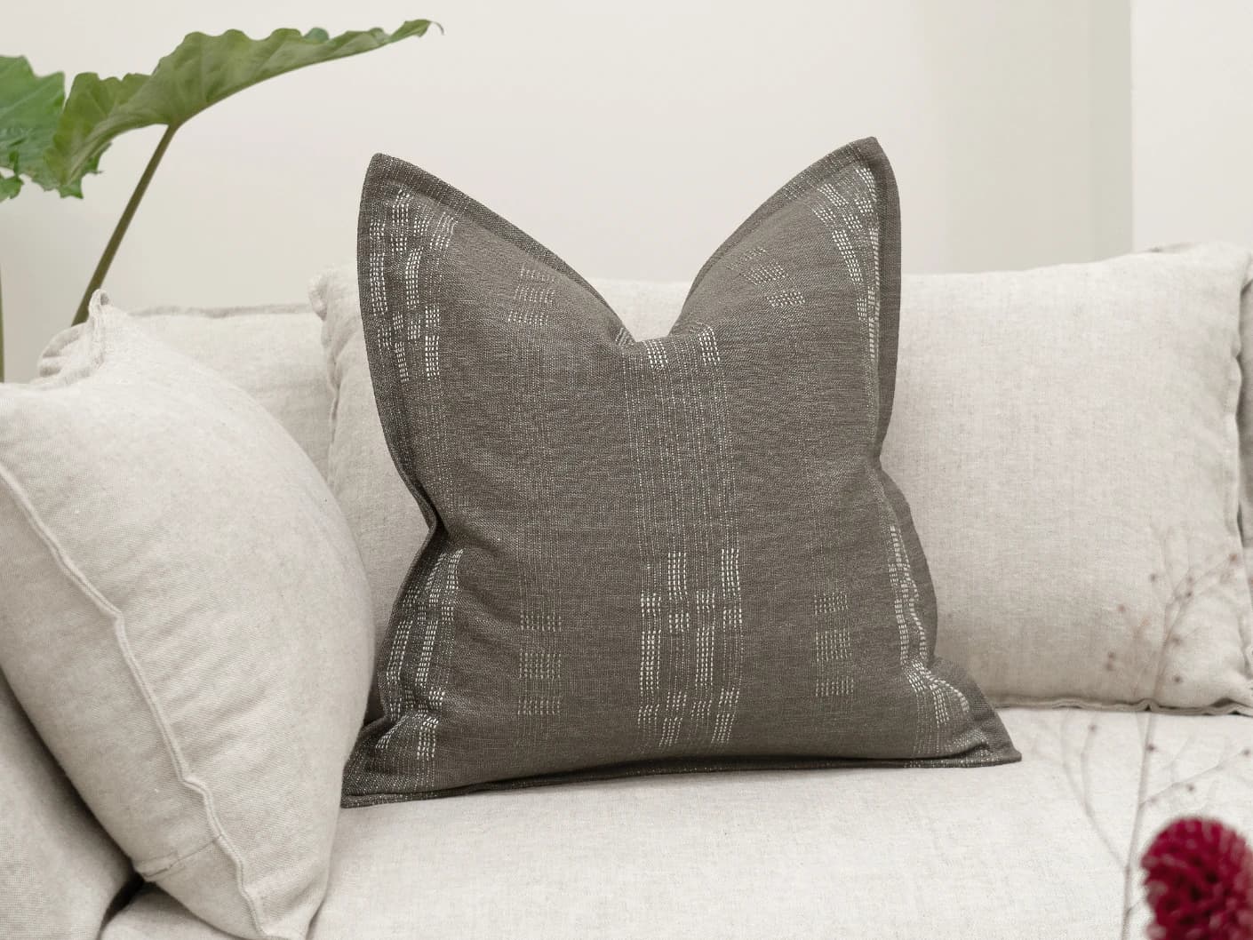 Yon Laurent single cushions in taupe and charcoal, shown in a lifestyle front view