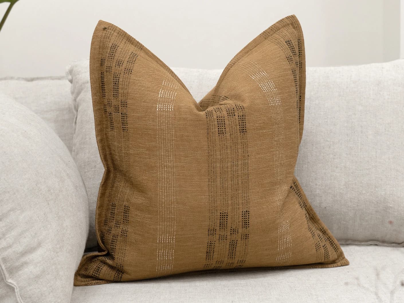 Yon Ochre single cushions in ochre and ochre brown, shown in a lifestyle front view