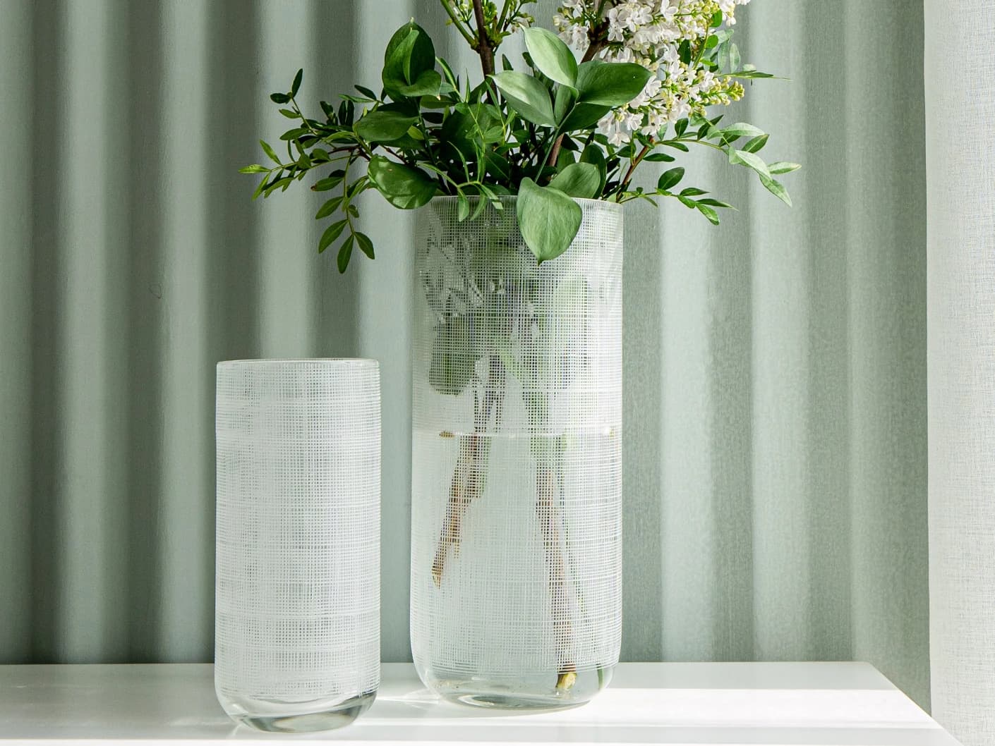 Zaha Bundle vases in white and translucent, shown in a lifestyle front view