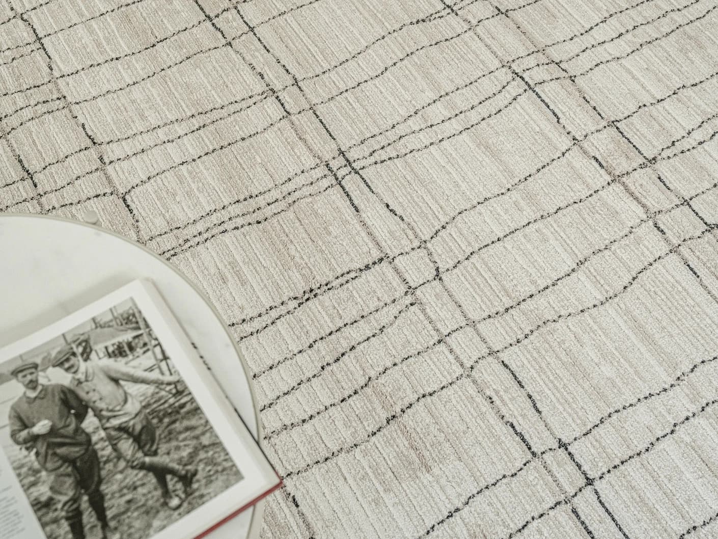 Zen Bianca Round carpet in charcoal and beige, shown in a lifestyle front view