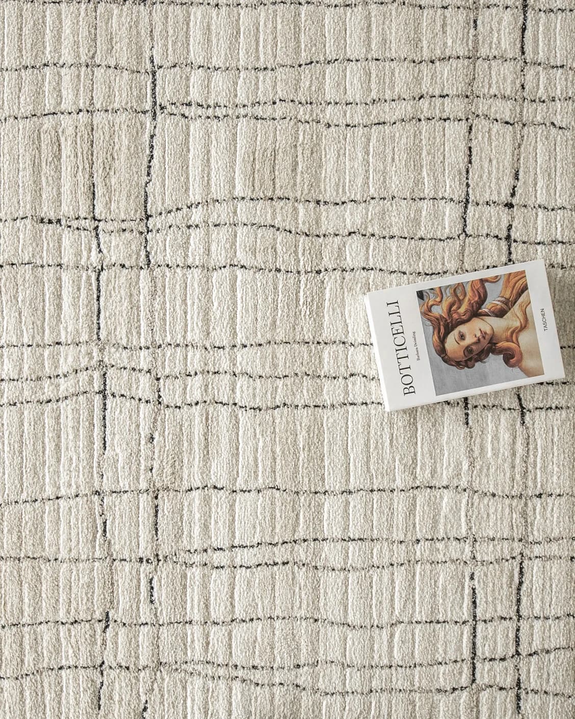Zen Bianca carpet in charcoal and beige, shown in a lifestyle top view as image 11