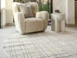 Zen Bianca Round carpet in charcoal and beige, shown in a lifestyle front view