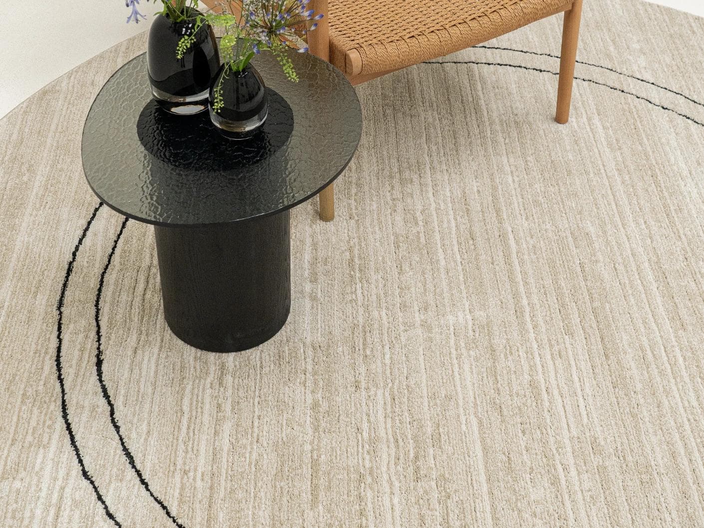 Zen Colin Round carpet in black and beige, shown in a lifestyle top view as image 4