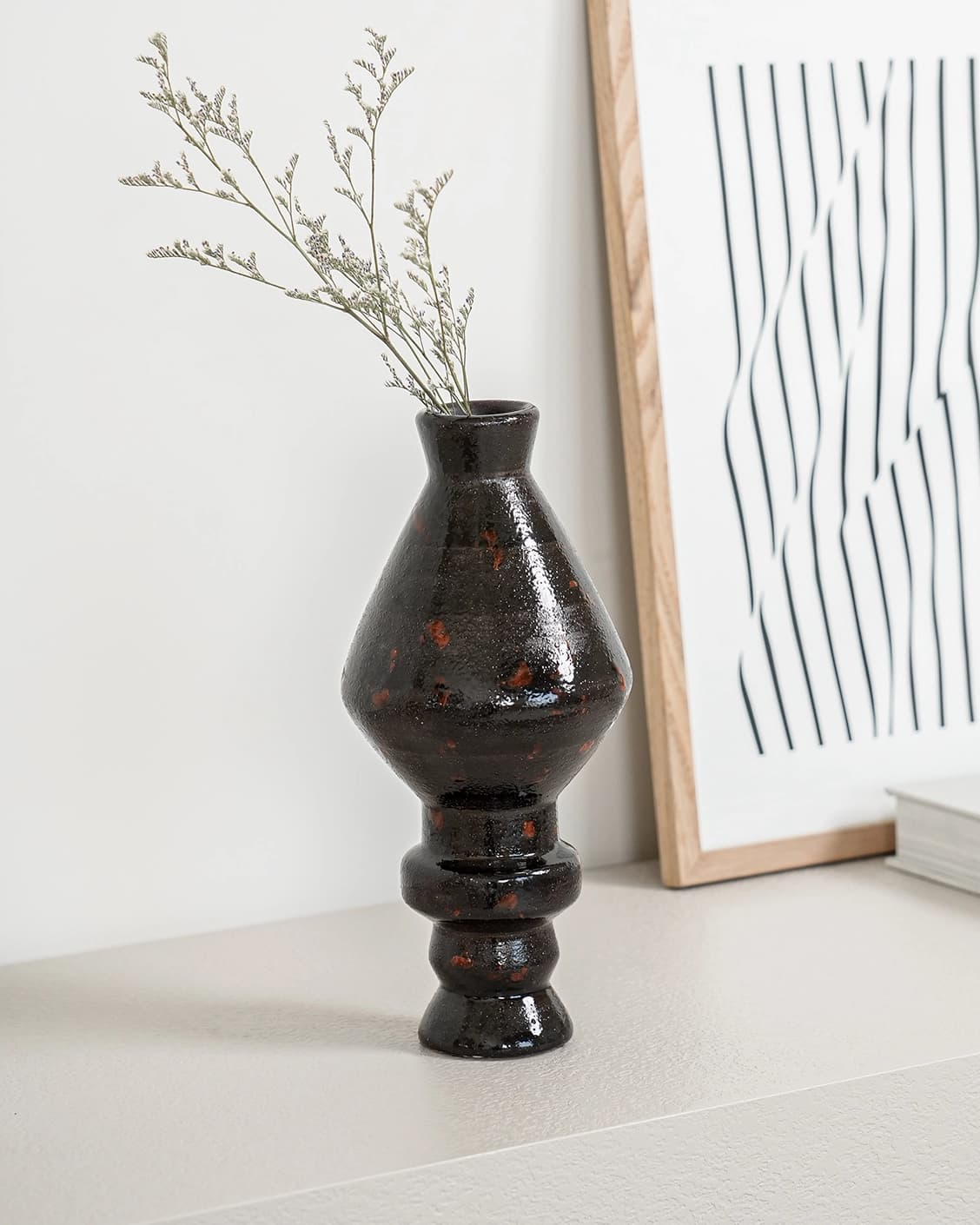 Zenith Terra I statues and sculptures in charcoal black and black, shown in a lifestyle left view