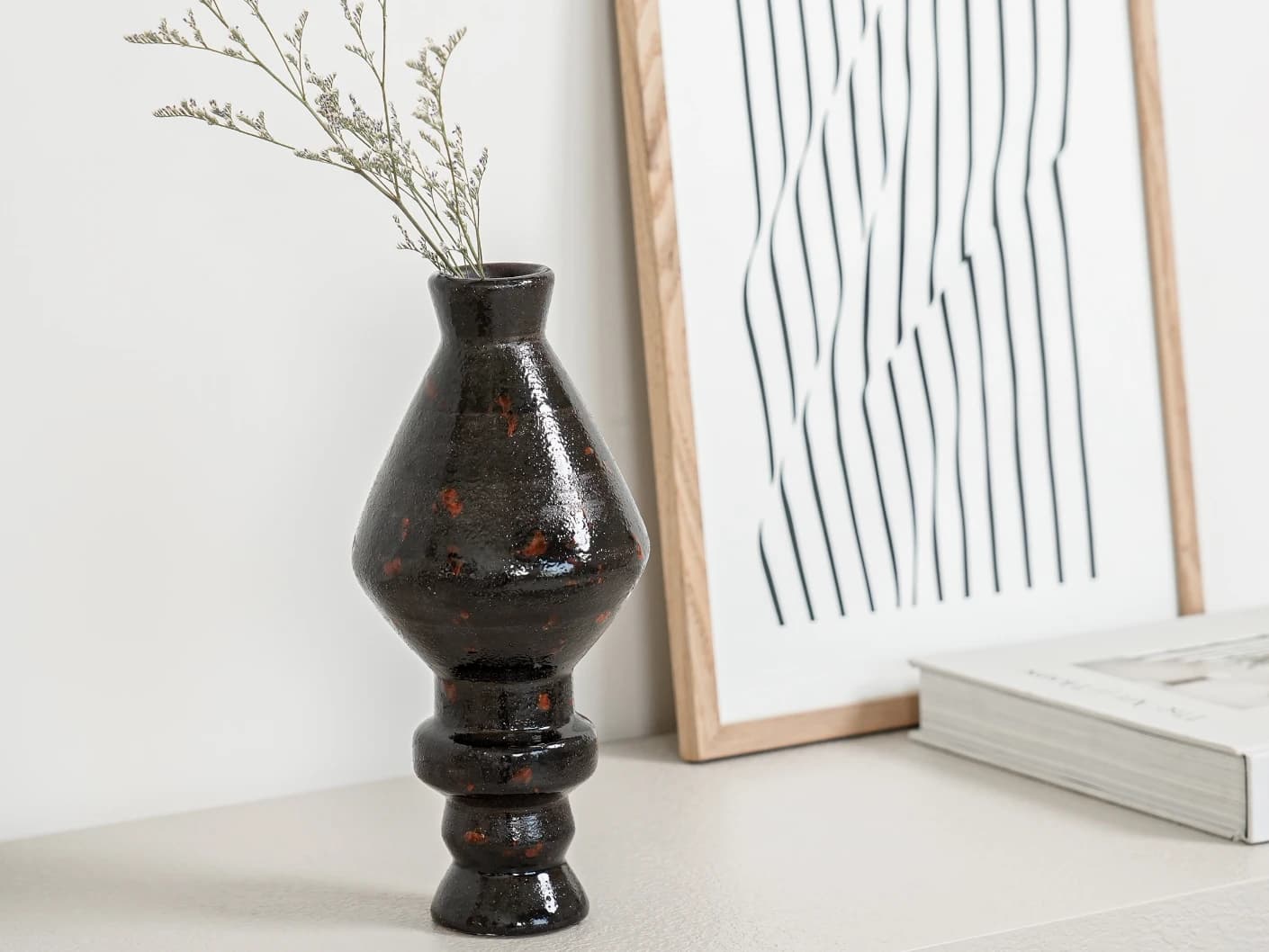 Zenith Terra I statues and sculptures in charcoal black and black, shown in a lifestyle left view