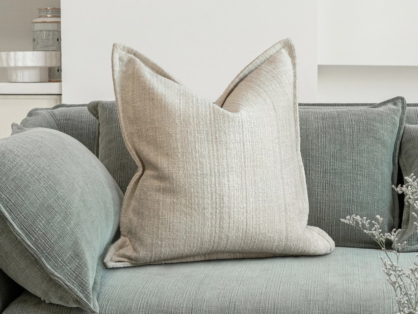 Zoe Laurent single cushions in beige, shown in a lifestyle front view