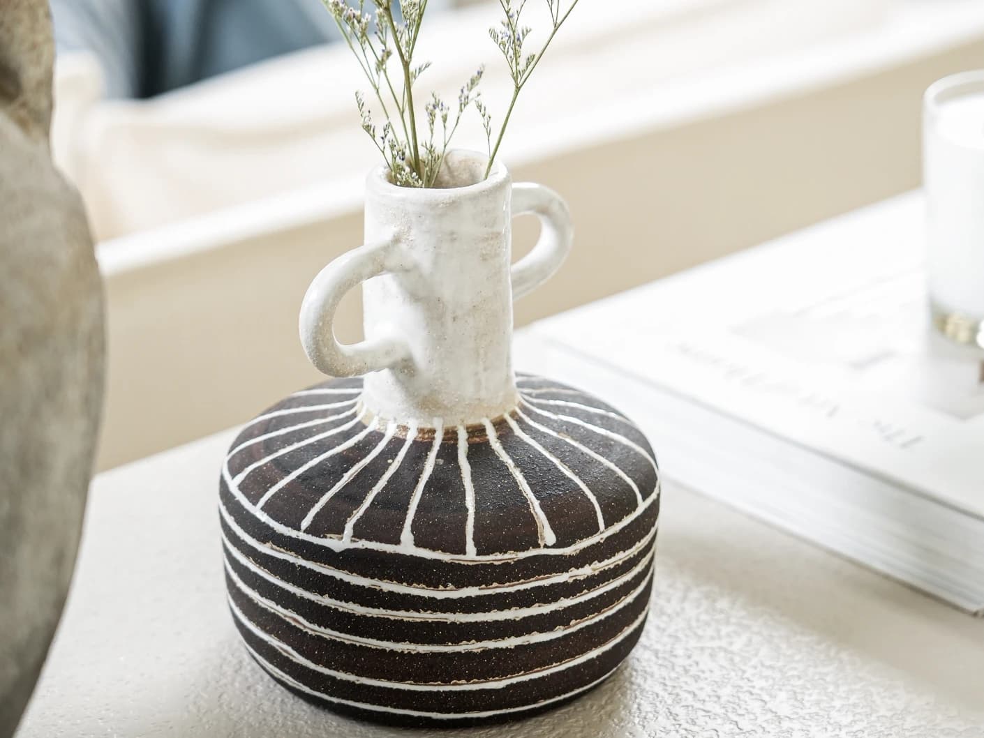 Zyra Terra vases in charcoal black, charcoal and white, shown in a lifestyle right view