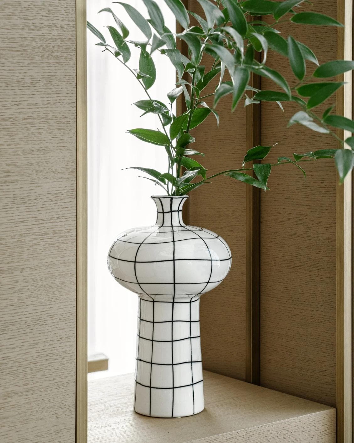 Iris Arneson vases in white and black, shown in a lifestyle left view as image 4