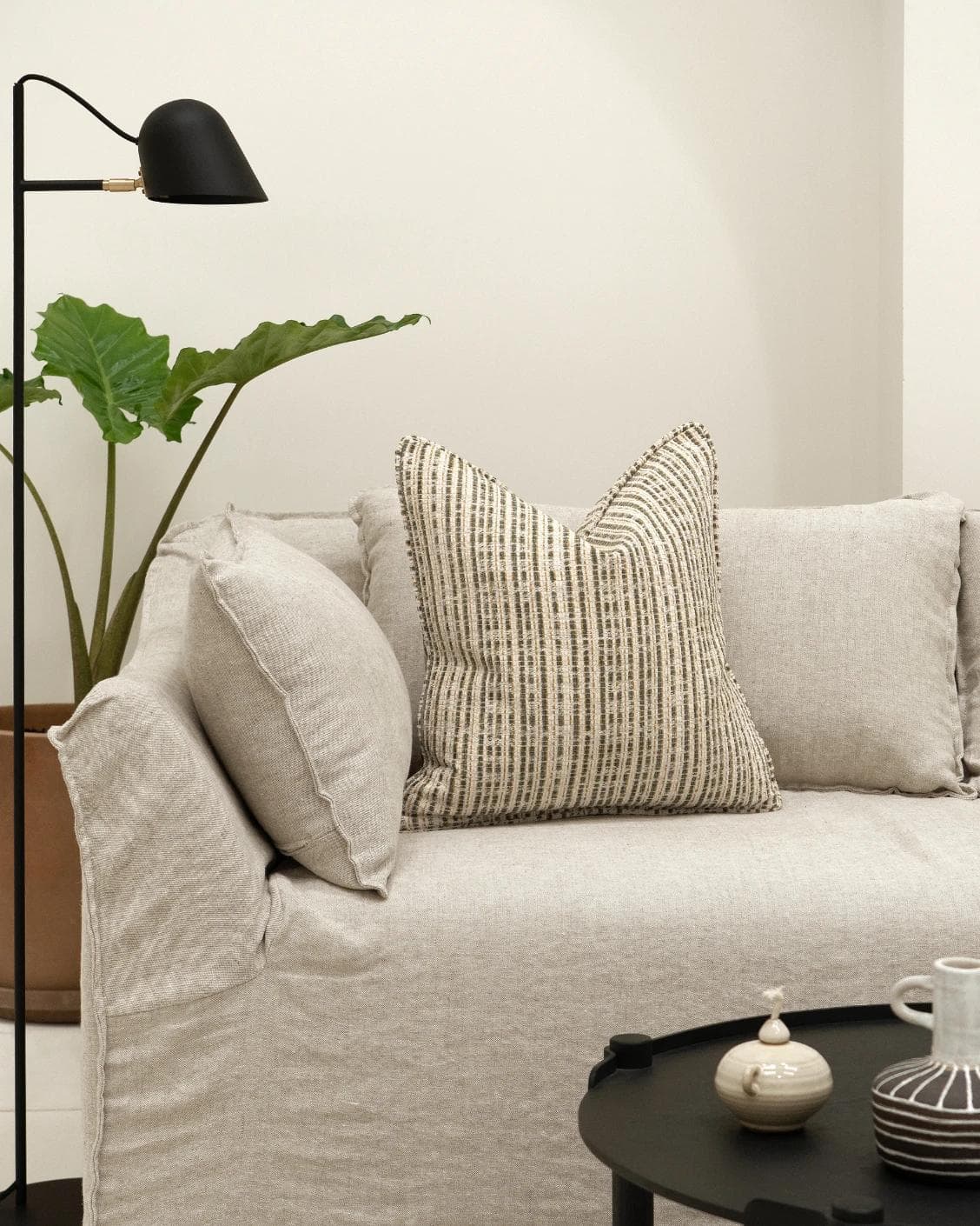 Izzy Olive cushion in ivory, shown in a lifestyle front view as image 4