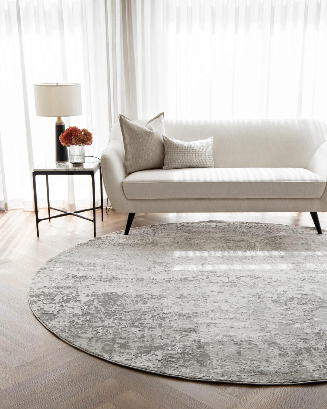 Jay Ashton Round carpet in grey, shown in a lifestyle front view