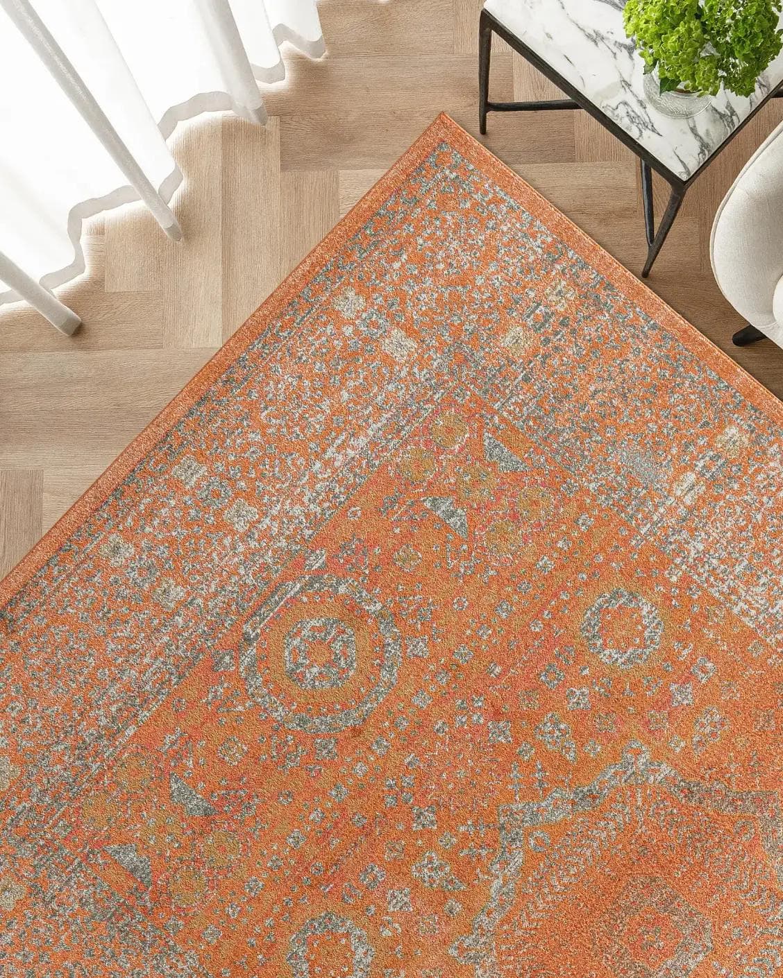 Julian Rust carpet in orange, shown in a lifestyle top view as image 2