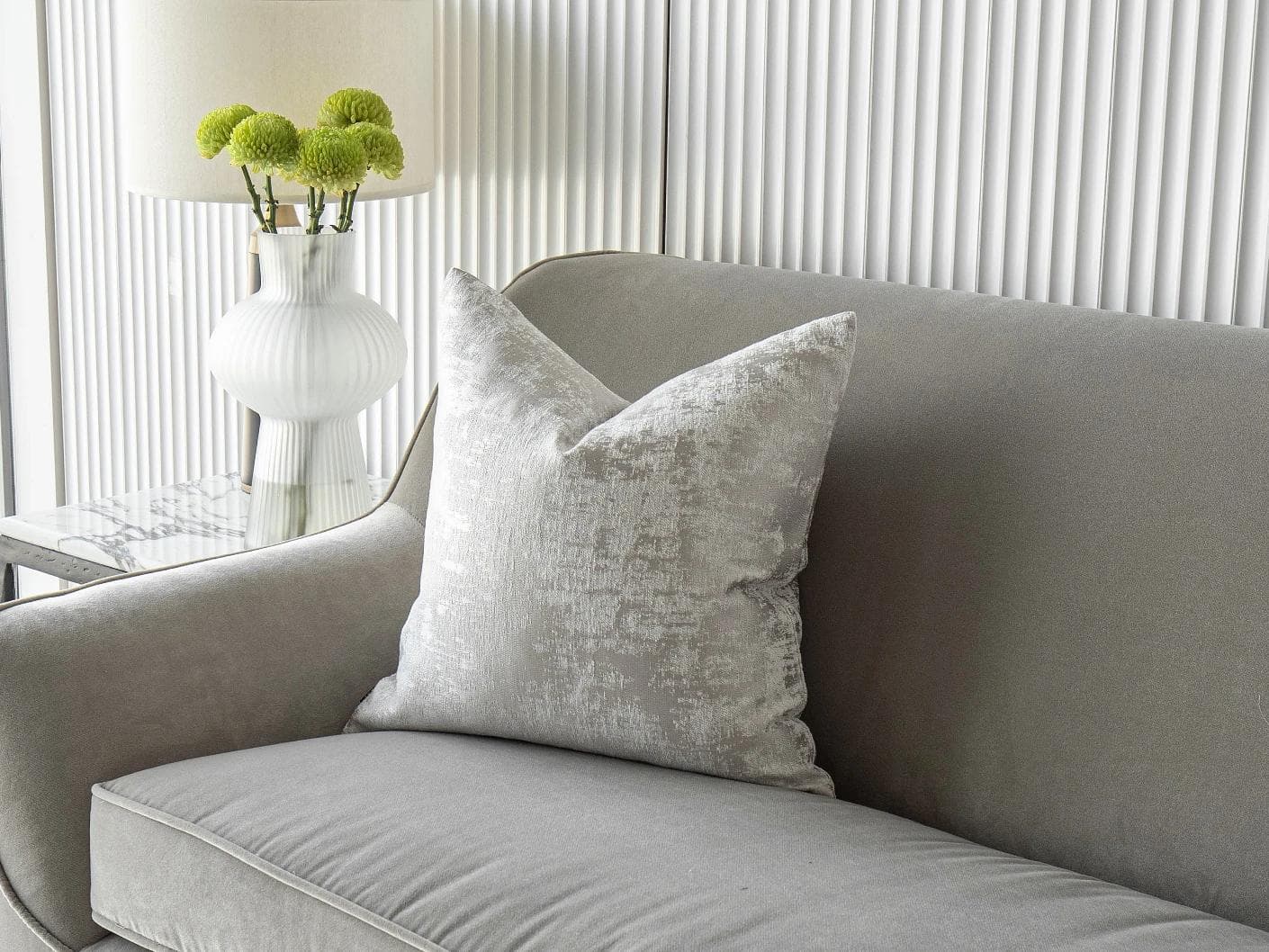 Kylie Hodler cushion in silver and grey, shown in a lifestyle front view as image 2