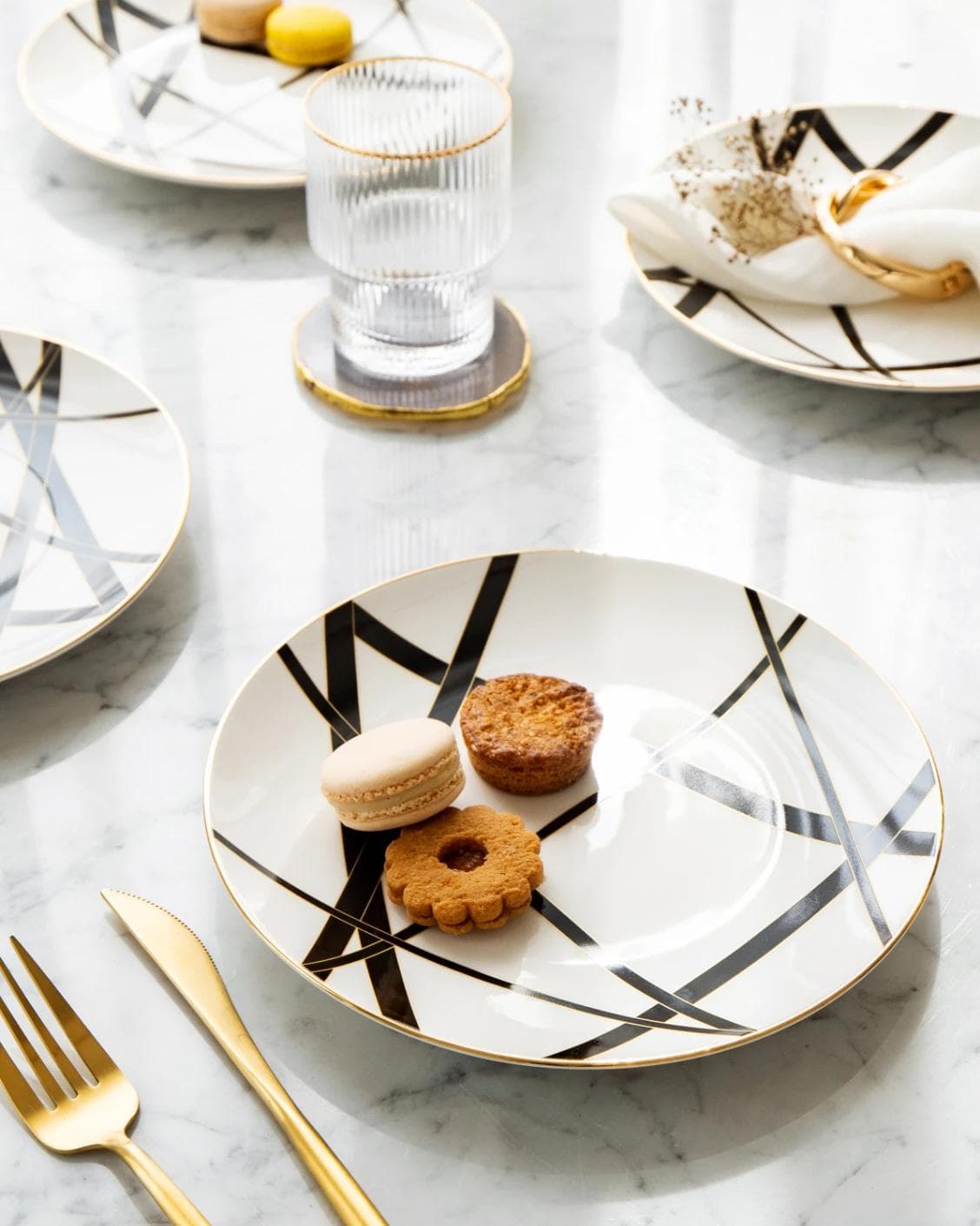 Leanna Viktoria plates in white, black and gold, shown in a lifestyle top view as image 2