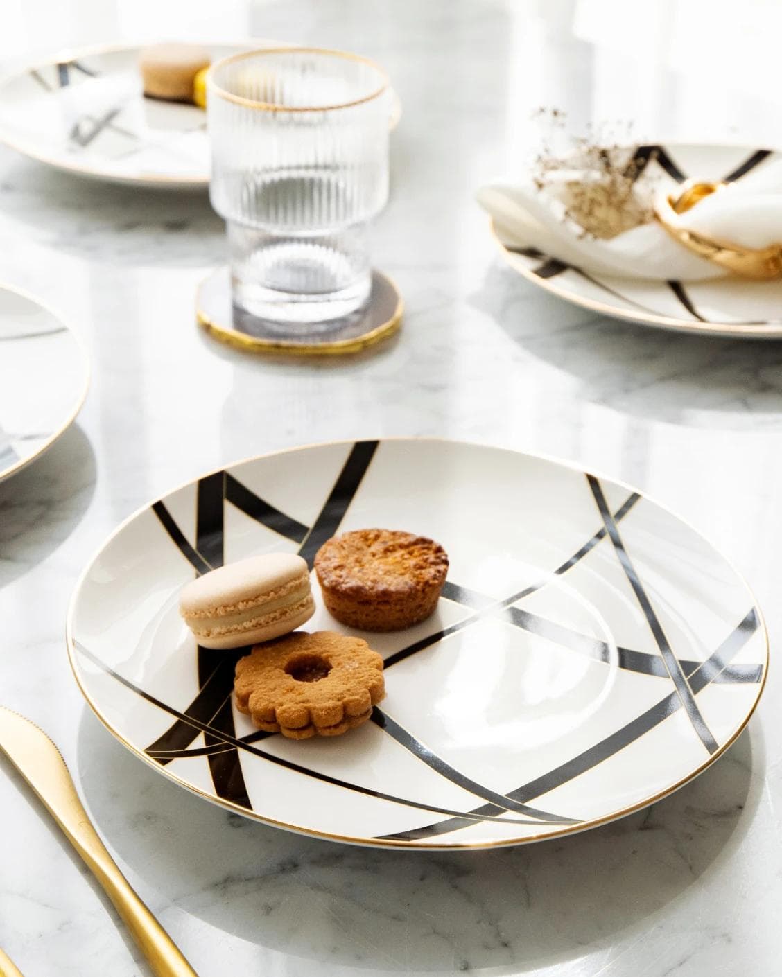 Leanna Viktoria plates in white, black and gold, shown in a lifestyle top view as image 6