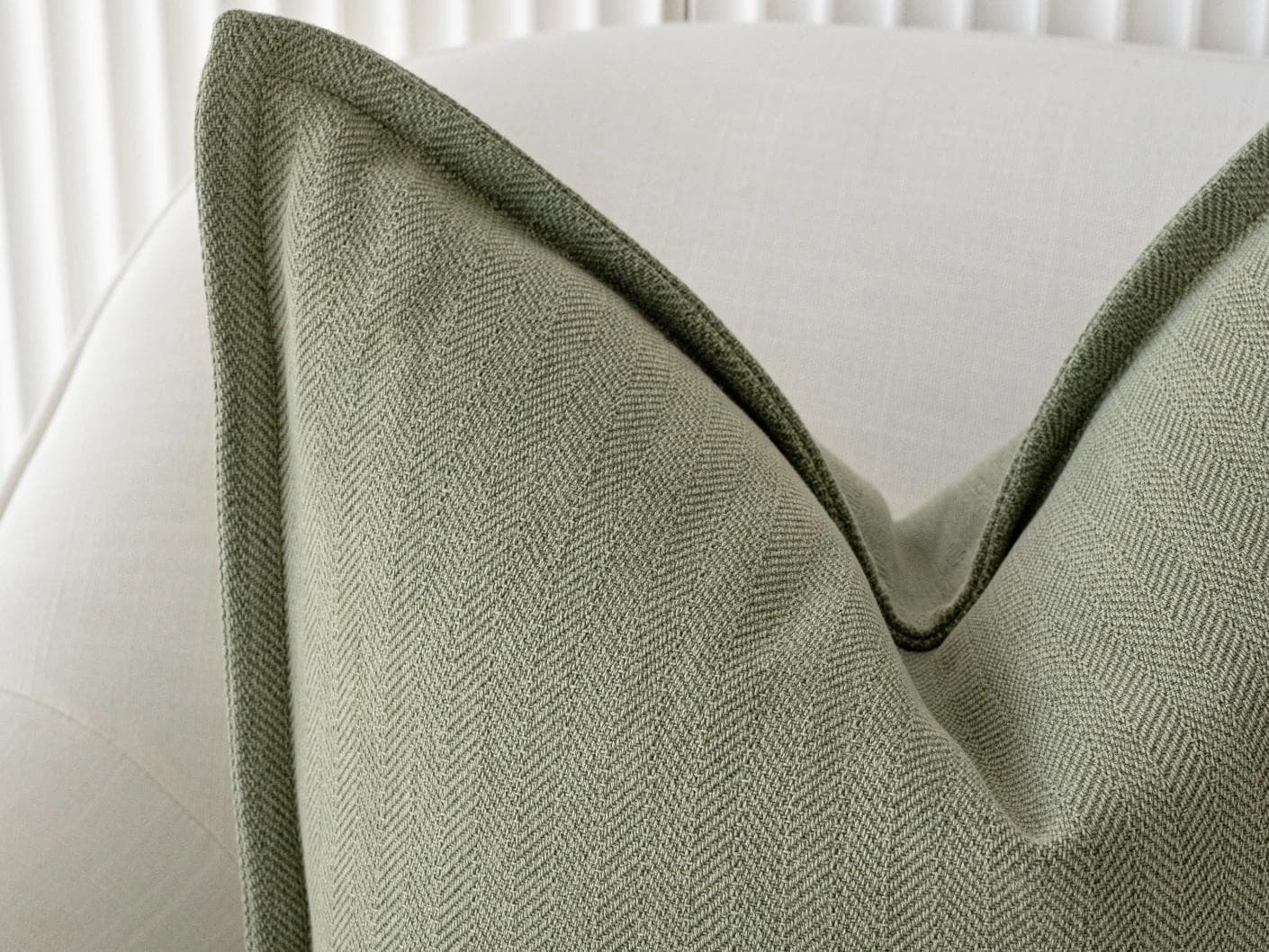 Lyndon Sage cushion in green, shown in a lifestyle front view as image 4