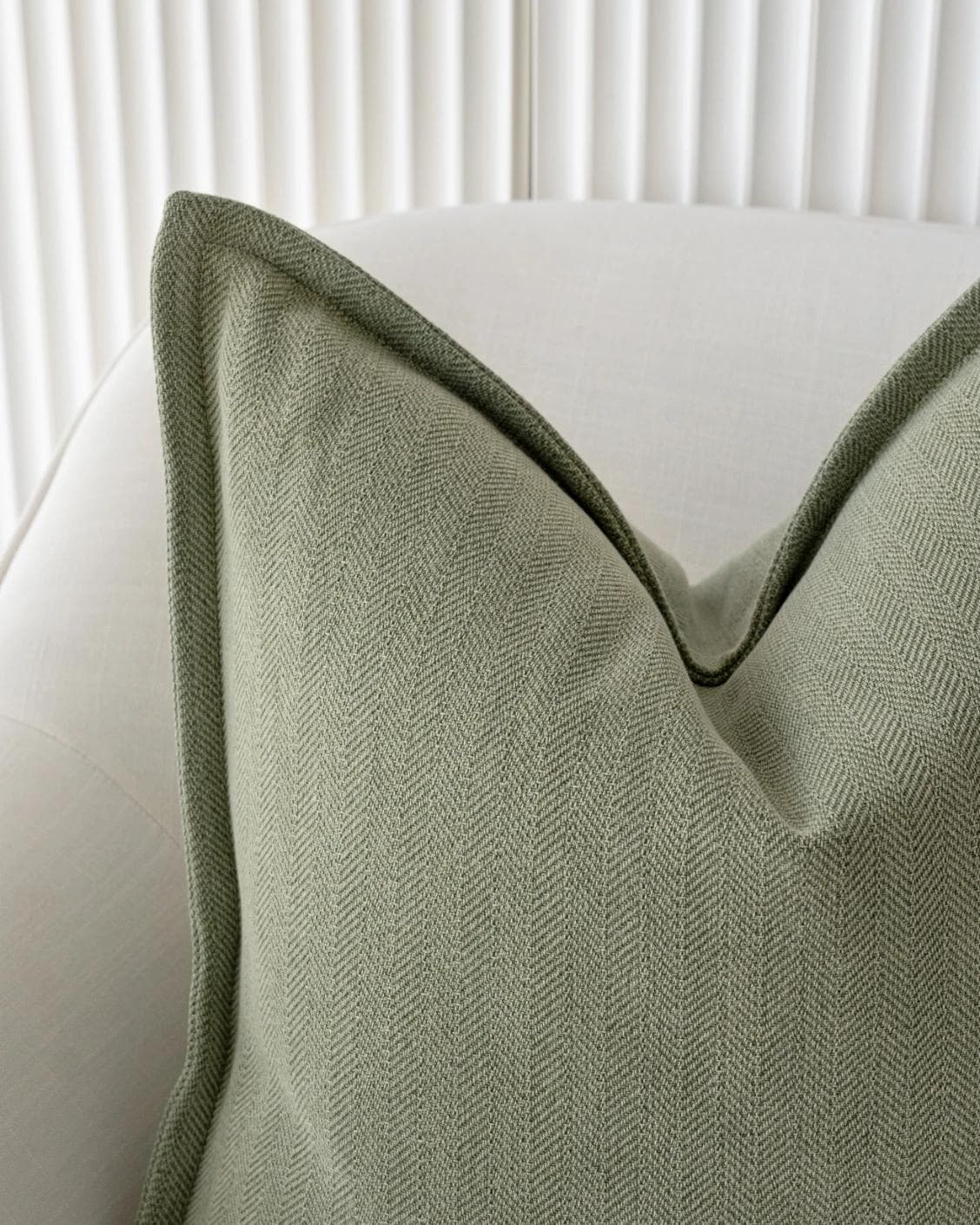 Lyndon Sage cushion in green, shown in a lifestyle front view as image 4