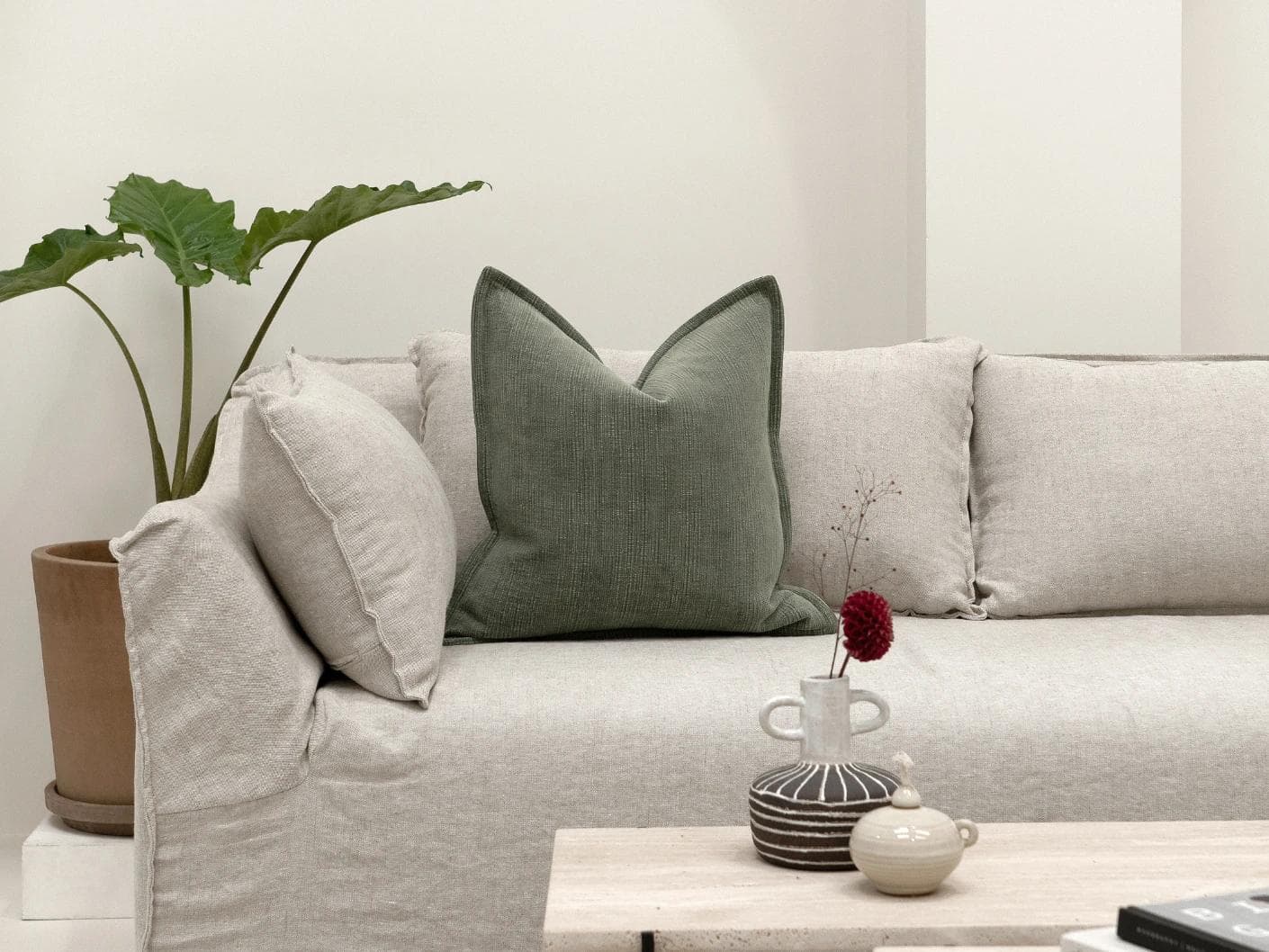 Macey Jade cushion in grey and green, shown in a lifestyle front view as image 4