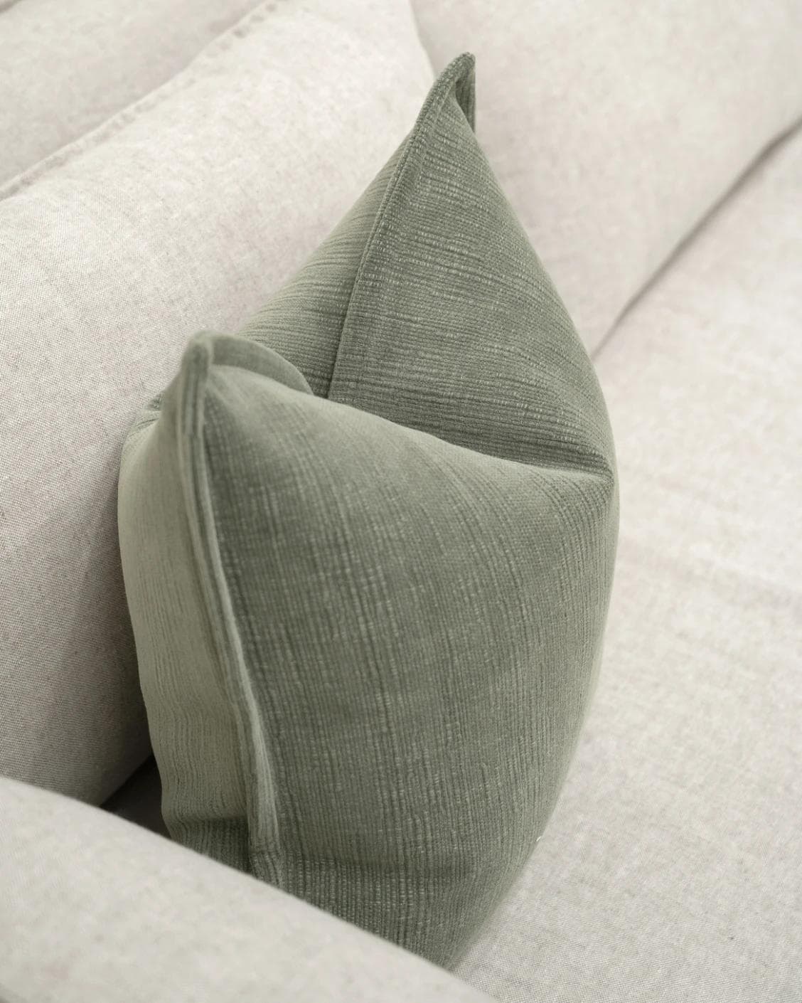 Macey Jade cushion in grey and green, shown in a lifestyle top view as image 5