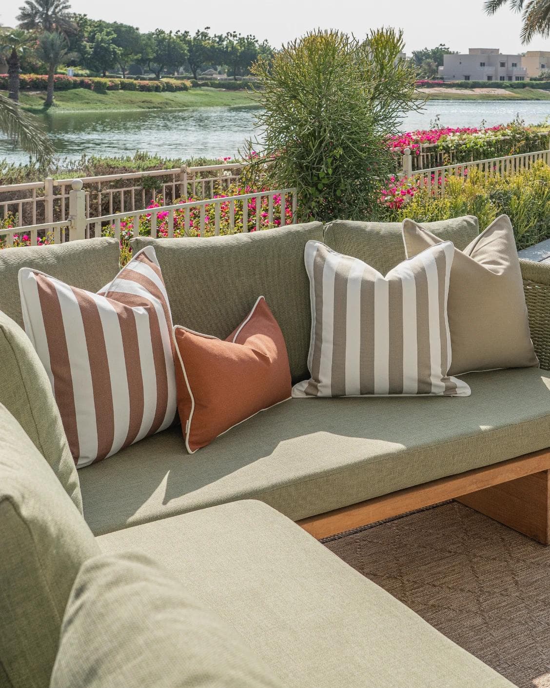 Manha Bundle cushion in rust and beige, shown in a lifestyle left view as image 2