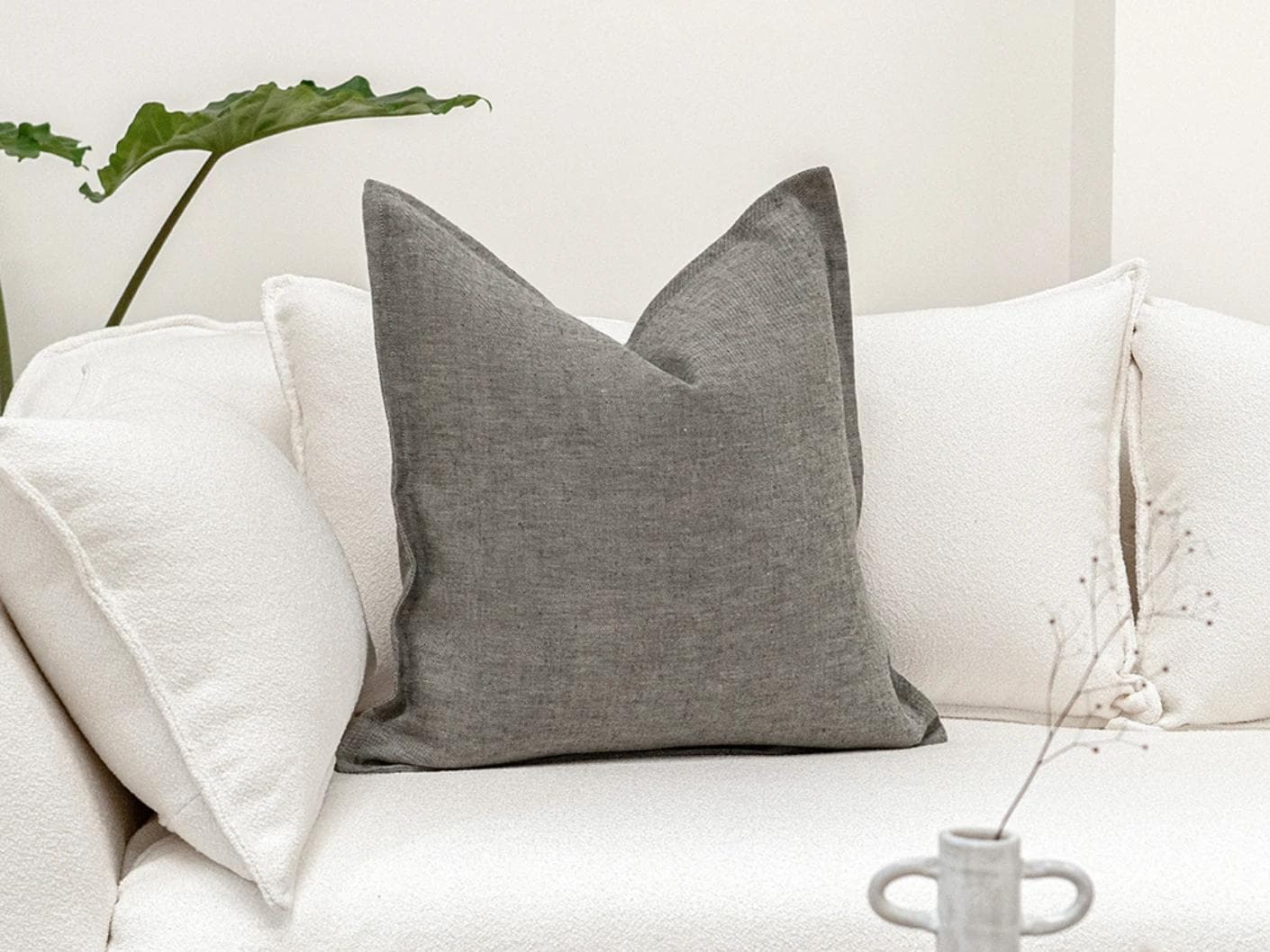 Mel Ash cushion in grey, shown in a lifestyle front view as image 2