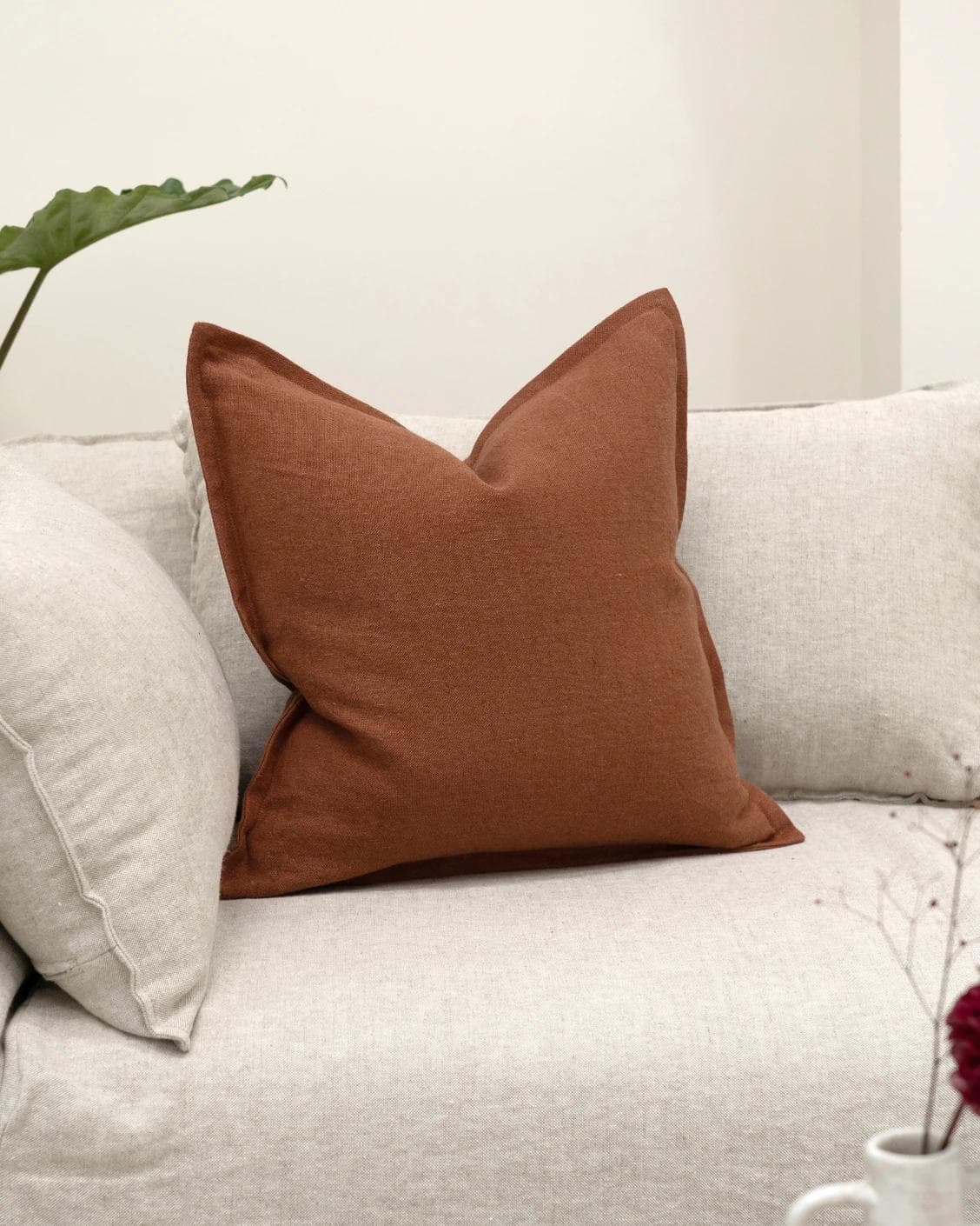 Mel Brick cushion in rust, shown in a lifestyle front view as image 2