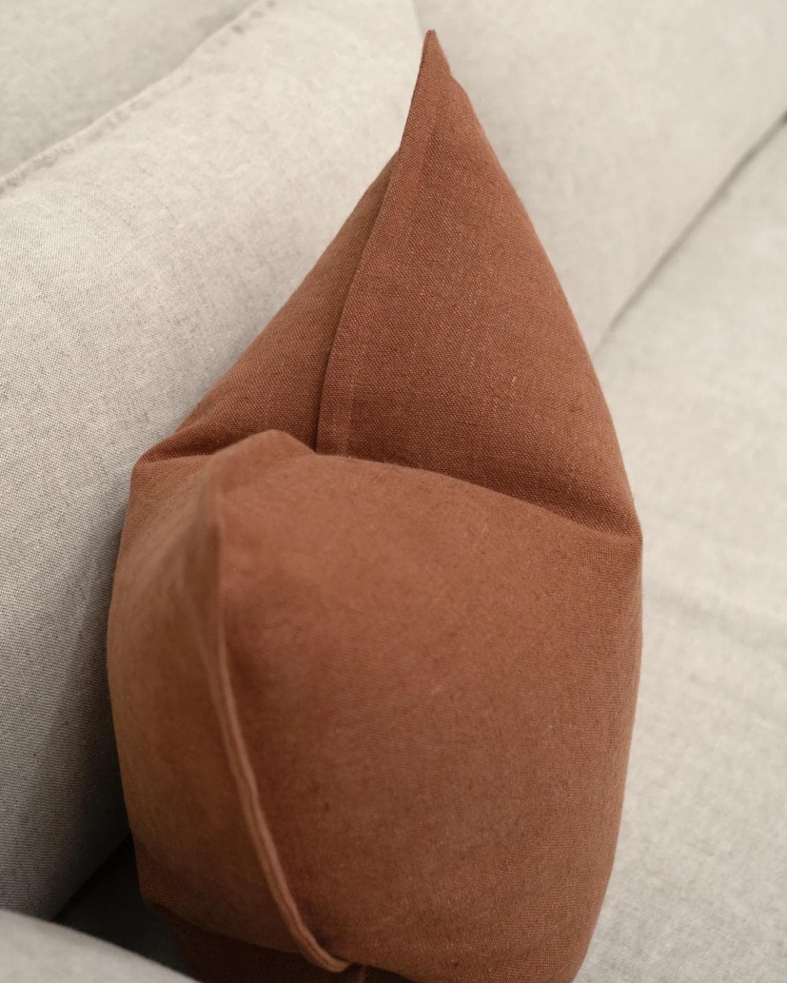 Mel Brick cushion in rust, shown in a lifestyle top view as image 5
