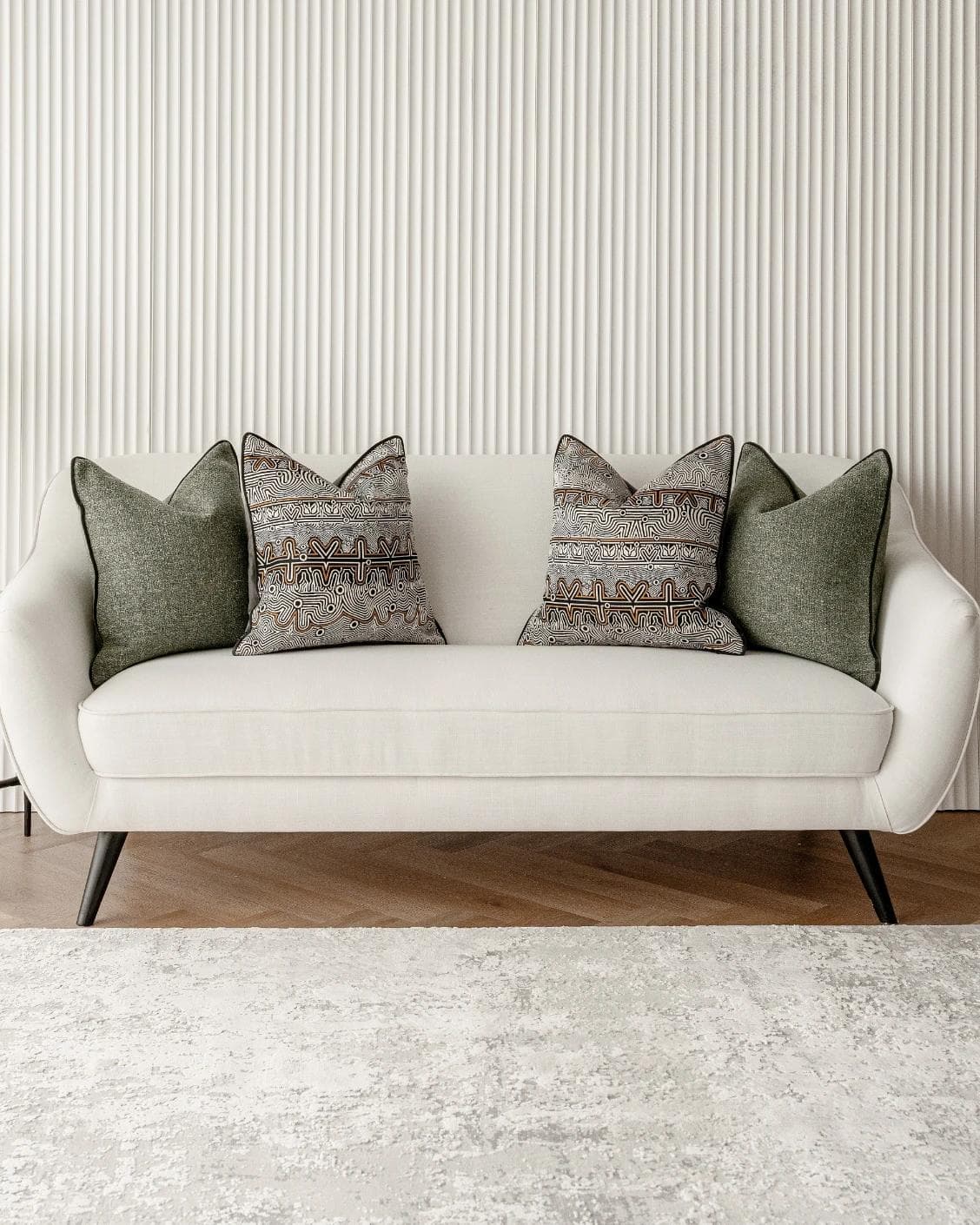 Mika Bundle cushion in black, silver and green, shown in a lifestyle front view as image 4