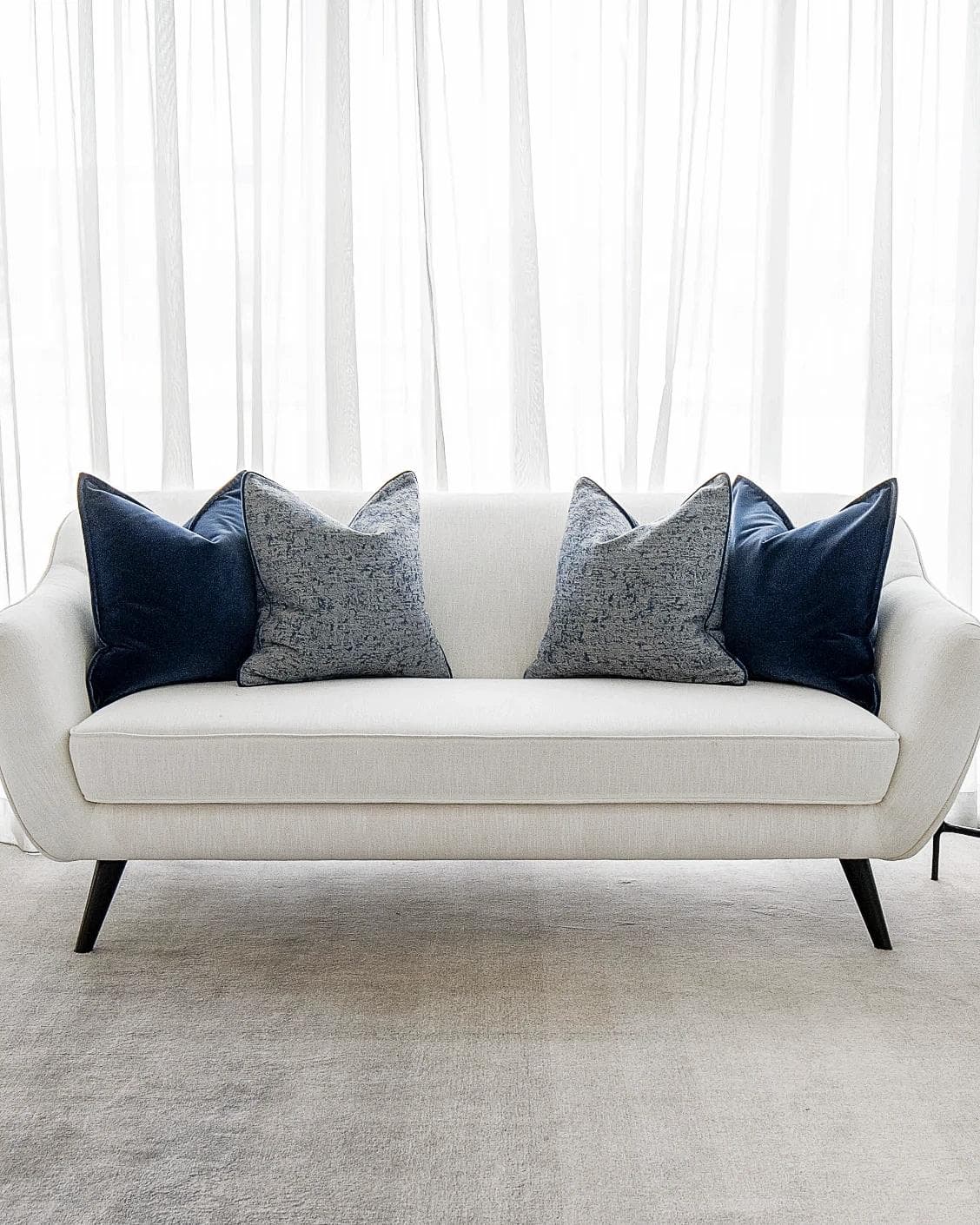 Clea Bundle cushion in navy, grey and royal blue, shown in a lifestyle front view as image 4