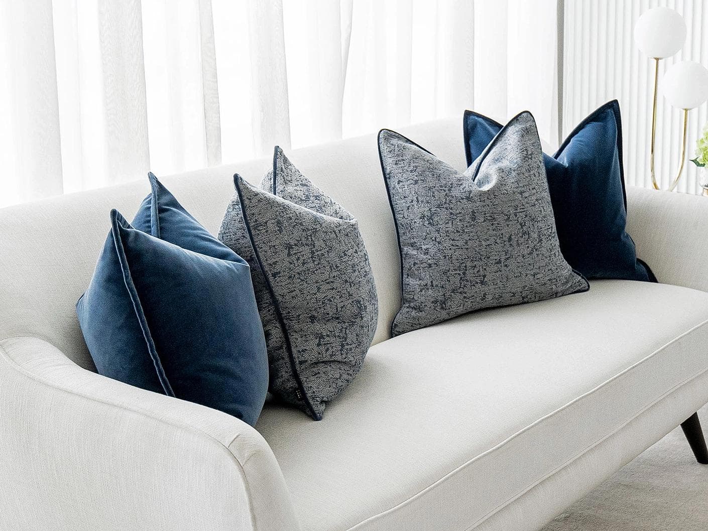 Clea Bundle cushion in navy, grey and royal blue, shown in a lifestyle left view as image 2