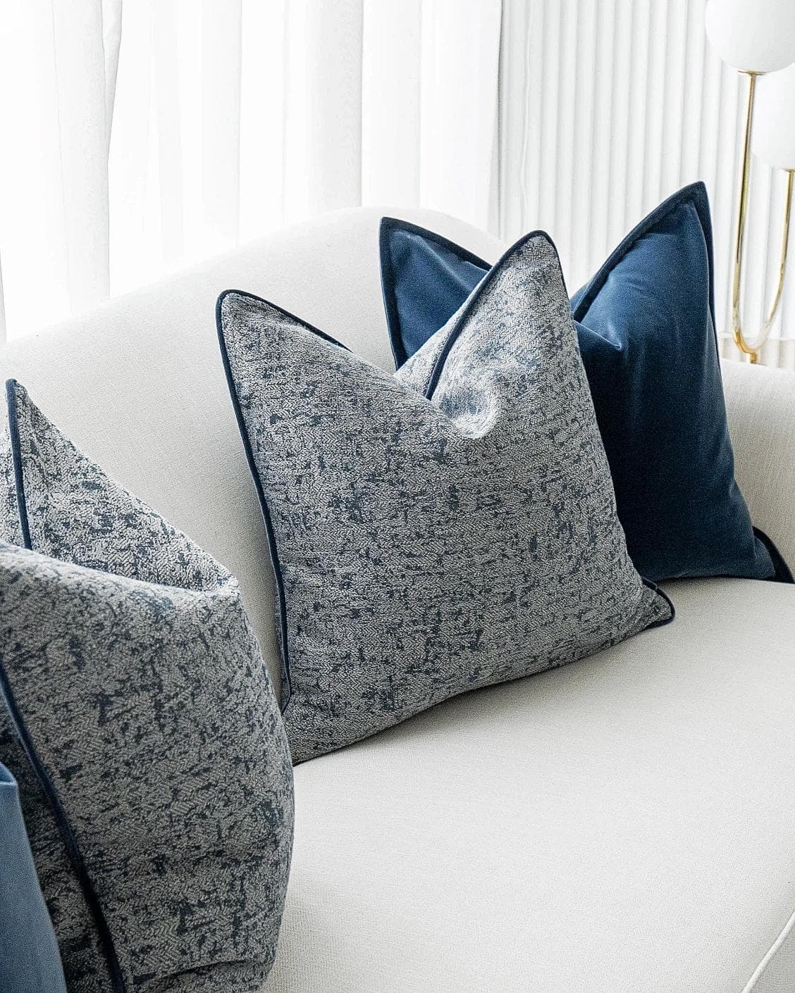 Clea Bundle cushion in navy, grey and royal blue, shown in a lifestyle left view as image 5