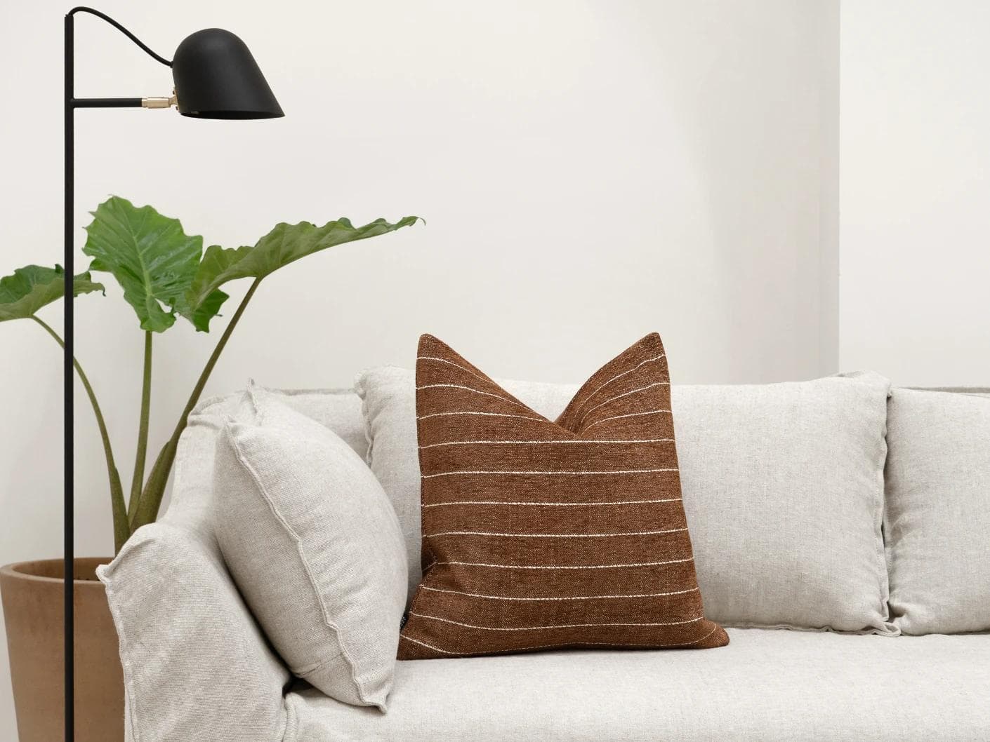 Noa Rust cushion in white and brown, shown in a lifestyle front view as image 4
