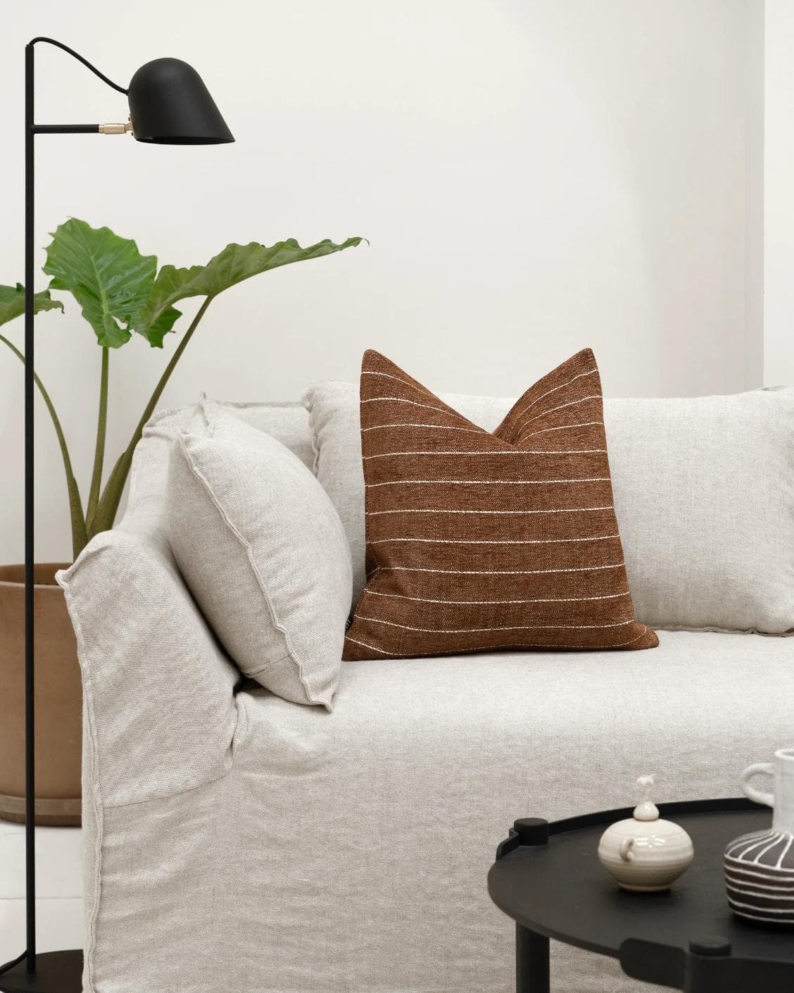 Noa Rust cushion in white and brown, shown in a lifestyle front view as image 4