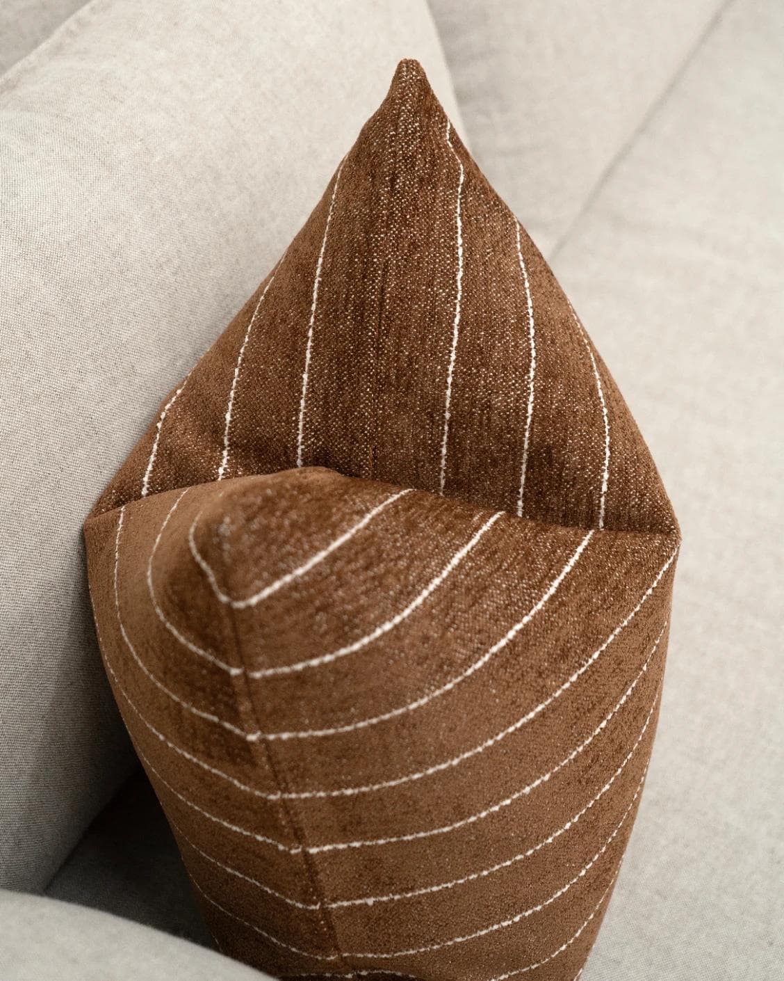 Noa Rust cushion in white and brown, shown in a lifestyle top view as image 5