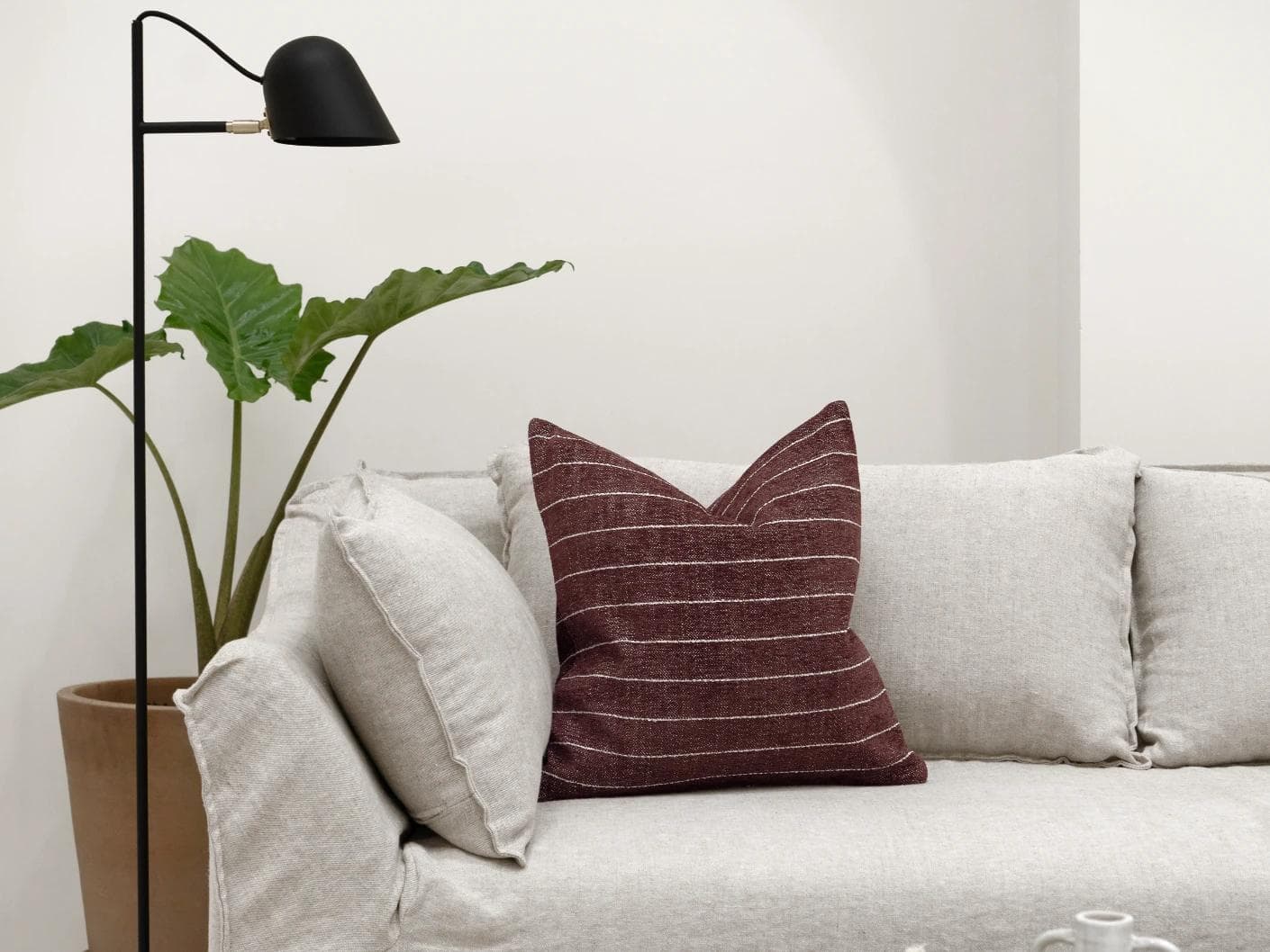 Noa Scarlet cushion in white and red, shown in a lifestyle front view as image 4