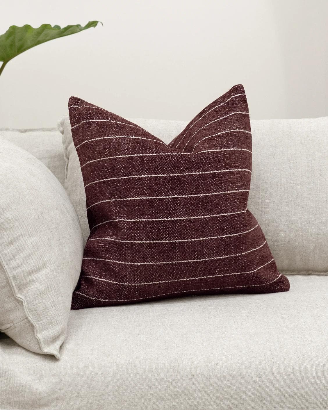 Noa Scarlet cushion in white and red, shown in a lifestyle front view as image 2
