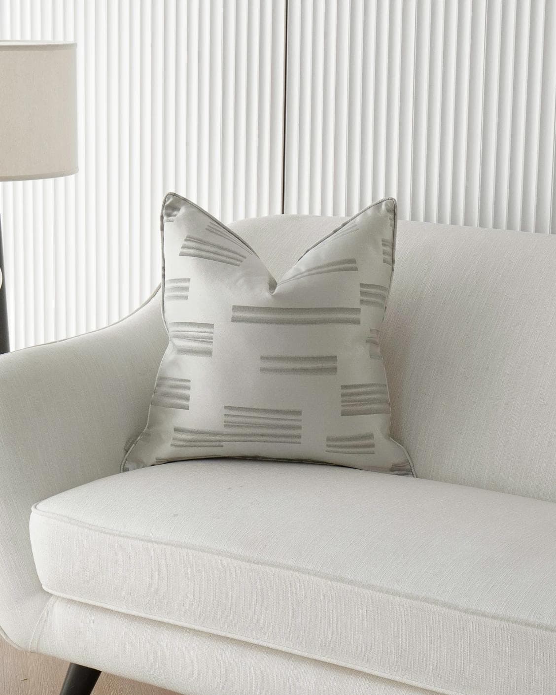 Nolan Laurent cushion in silver and grey, shown in a lifestyle front view as image 5