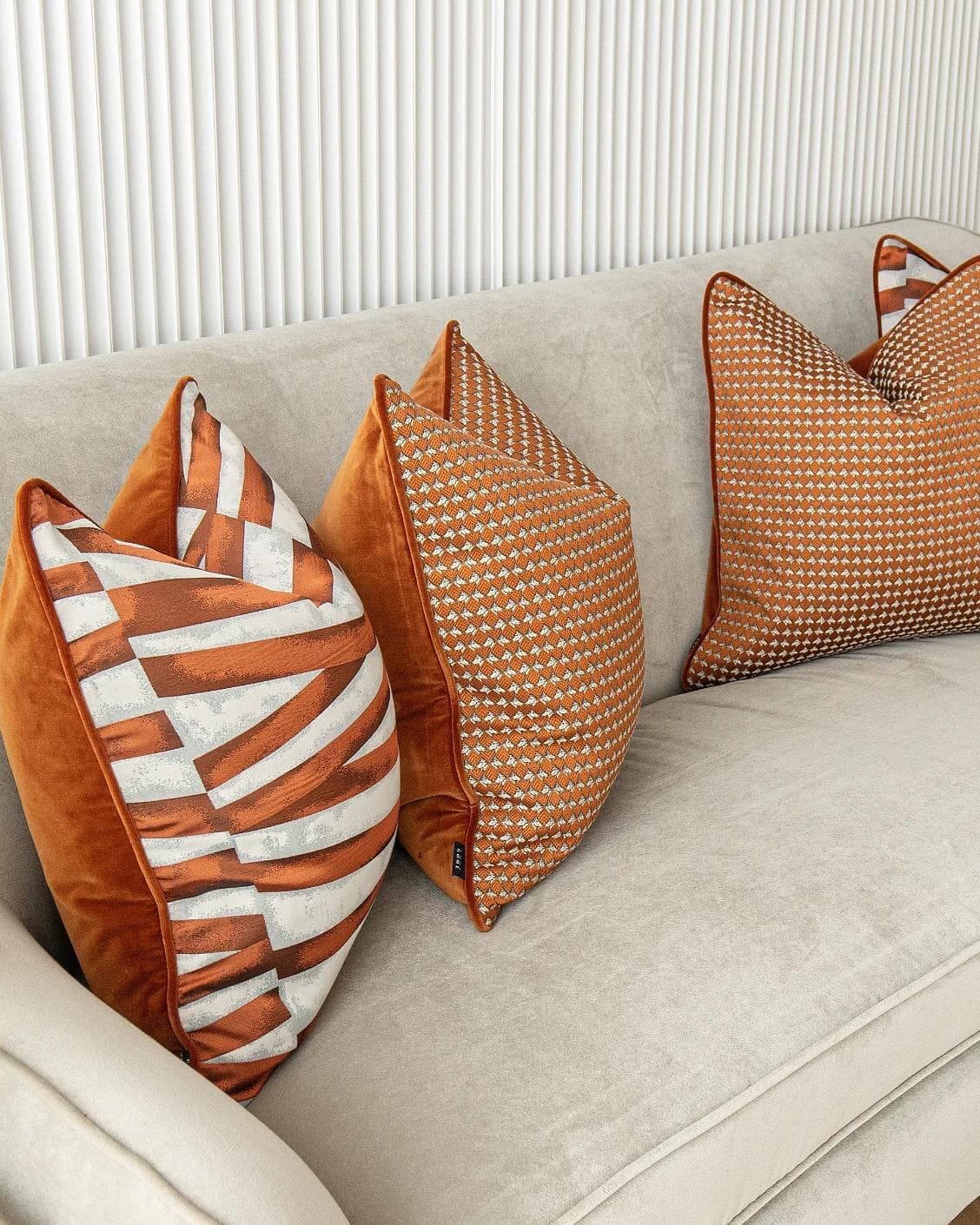 Alfred Bundle cushion in orange and white, shown in a lifestyle left view as image 5