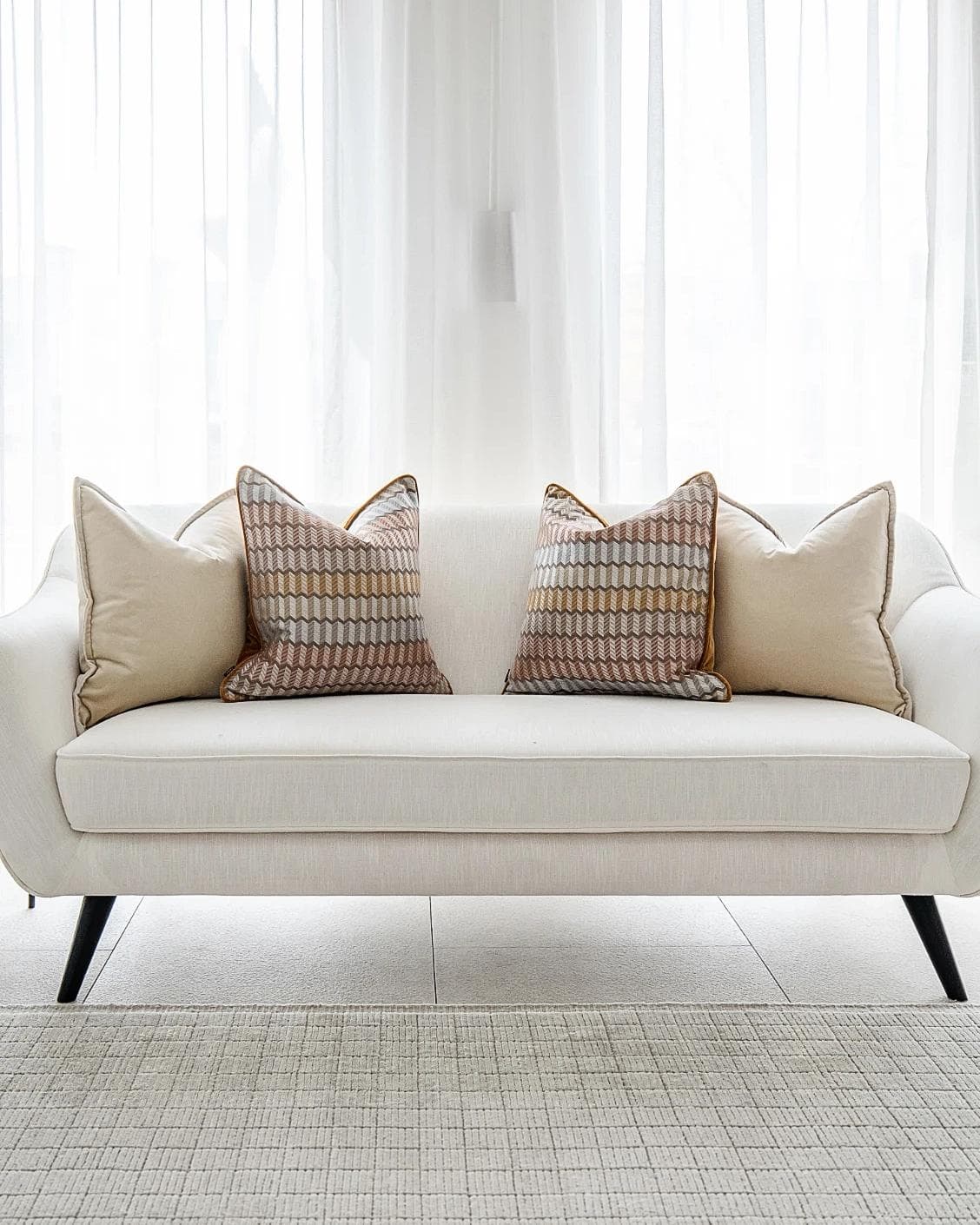 Elanor Bundle cushion in orange, yellow, beige and silver, shown in a lifestyle front view as image 4