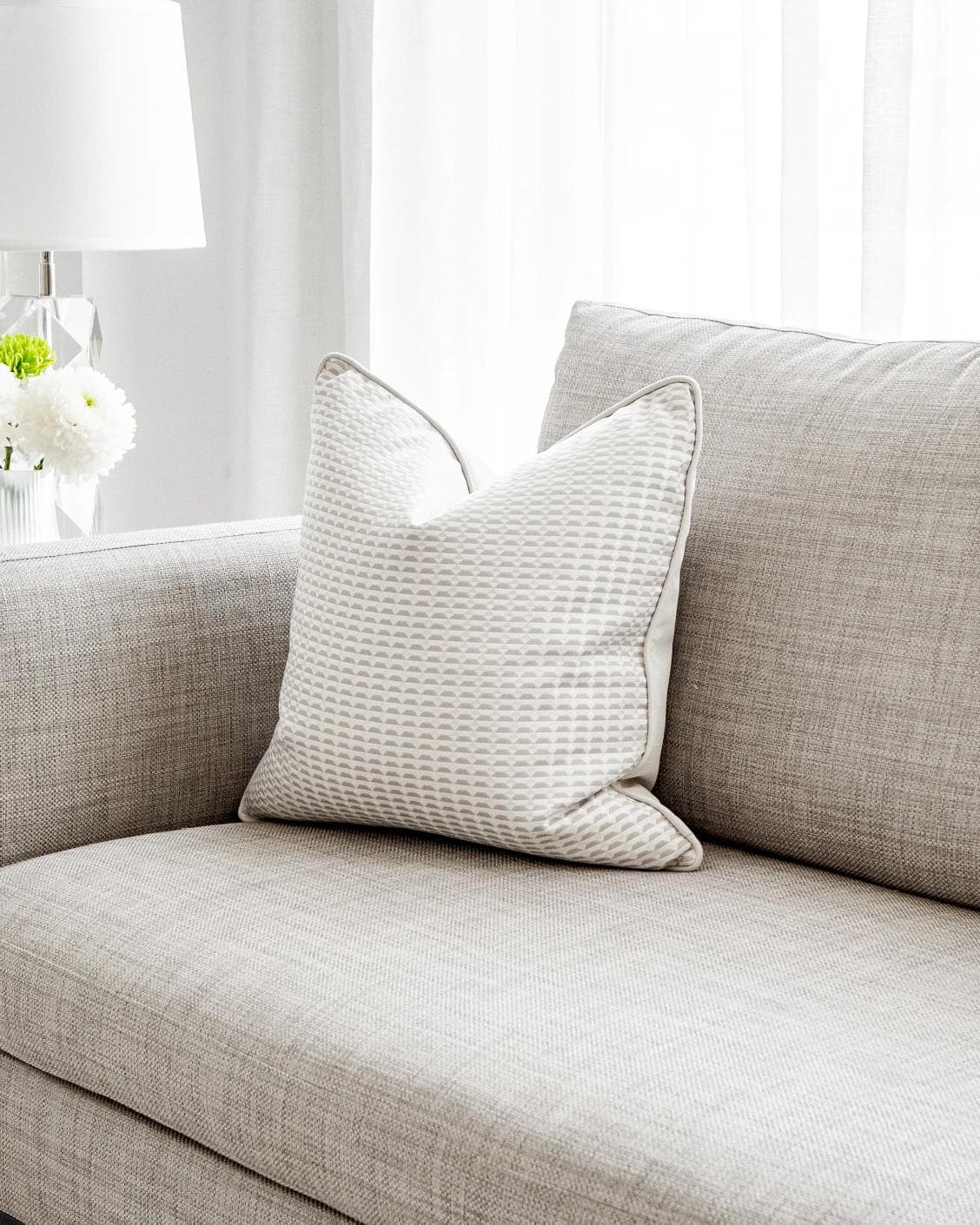 Paola Laurent cushion in white and beige, shown in a lifestyle front view as image 2