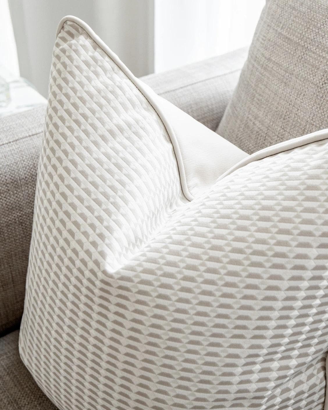 Paola Laurent cushion in white and beige, shown in a lifestyle top view as image 5