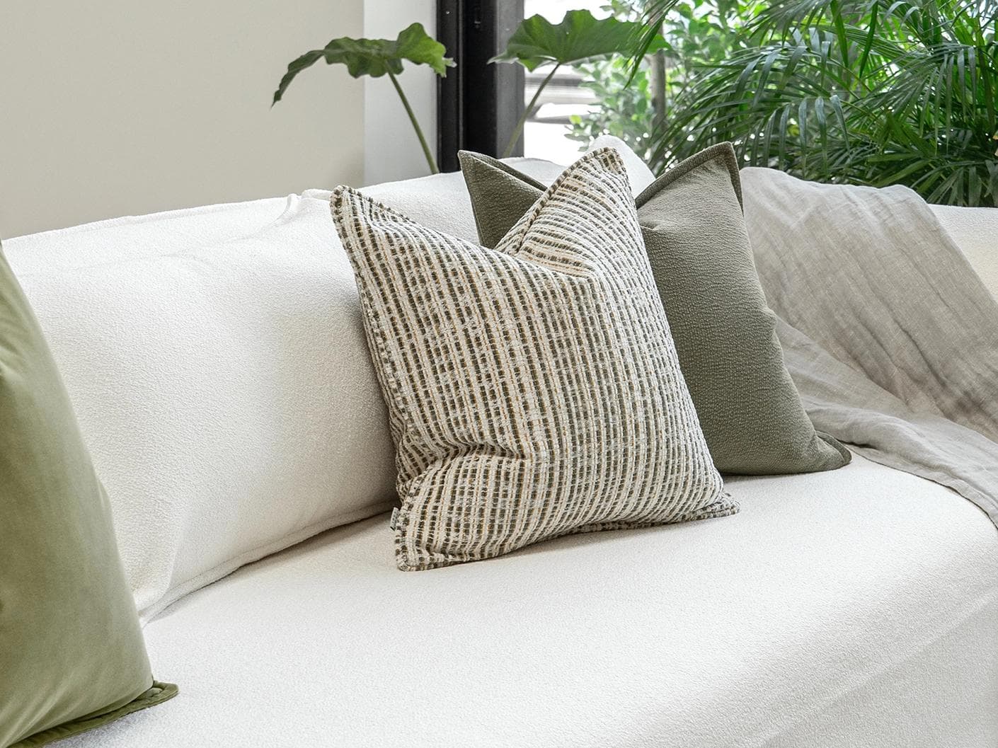Praveen Bundle cushion in green and cream, shown in a lifestyle left view as image 2