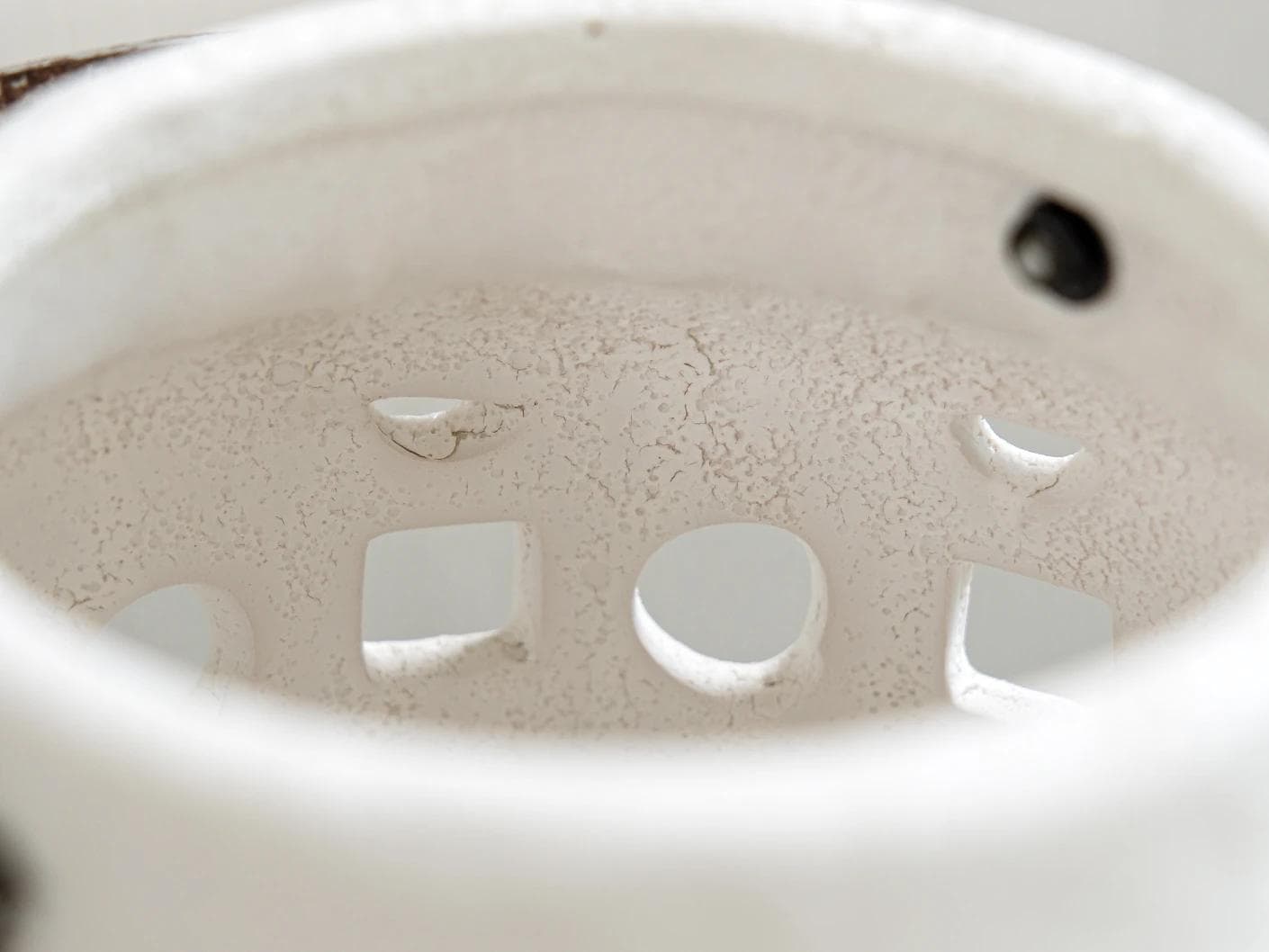Reba Terra candle holders in soft ivory and ivory, shown in a lifestyle close-up top view as image 1